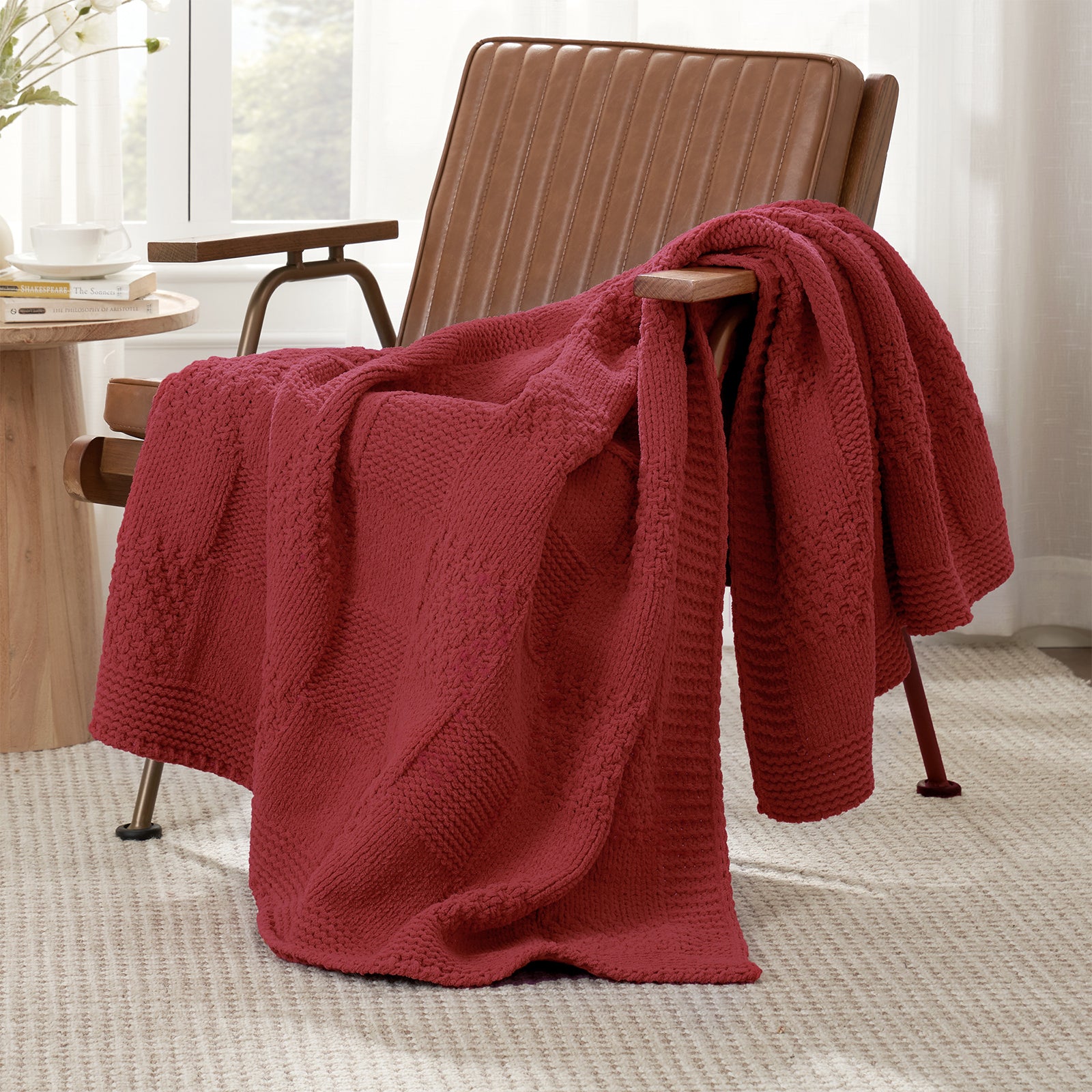 Checkered Chenille Knit Throw Blanket in Red draped over a lounge chair, showcasing soft chenille knit texture and cozy checkered design. #color_Christmas Red