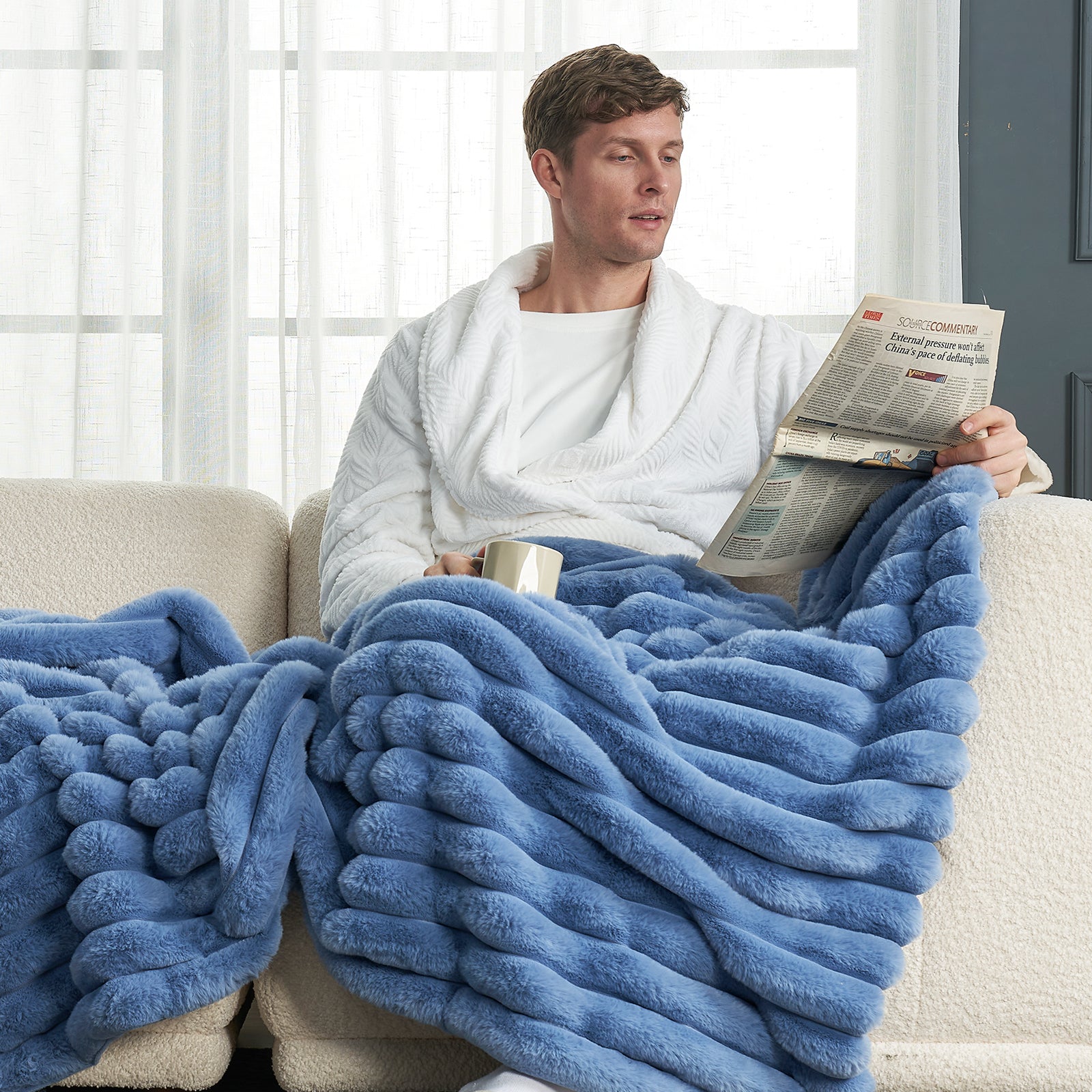 Man relaxing under a blue striped faux fur blanket from Cozy Bliss, enjoying cozy bedding. #color_Light Blue