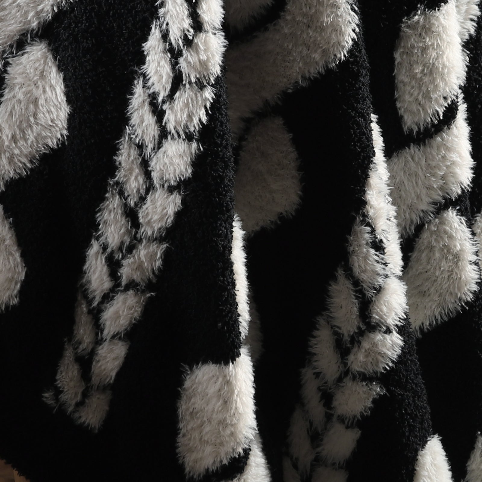 Close-up of cable knit pattern on Faux Mink Cable Knit Throw Blanket in Black highlighting soft faux mink fibers and textured design. #color_Black