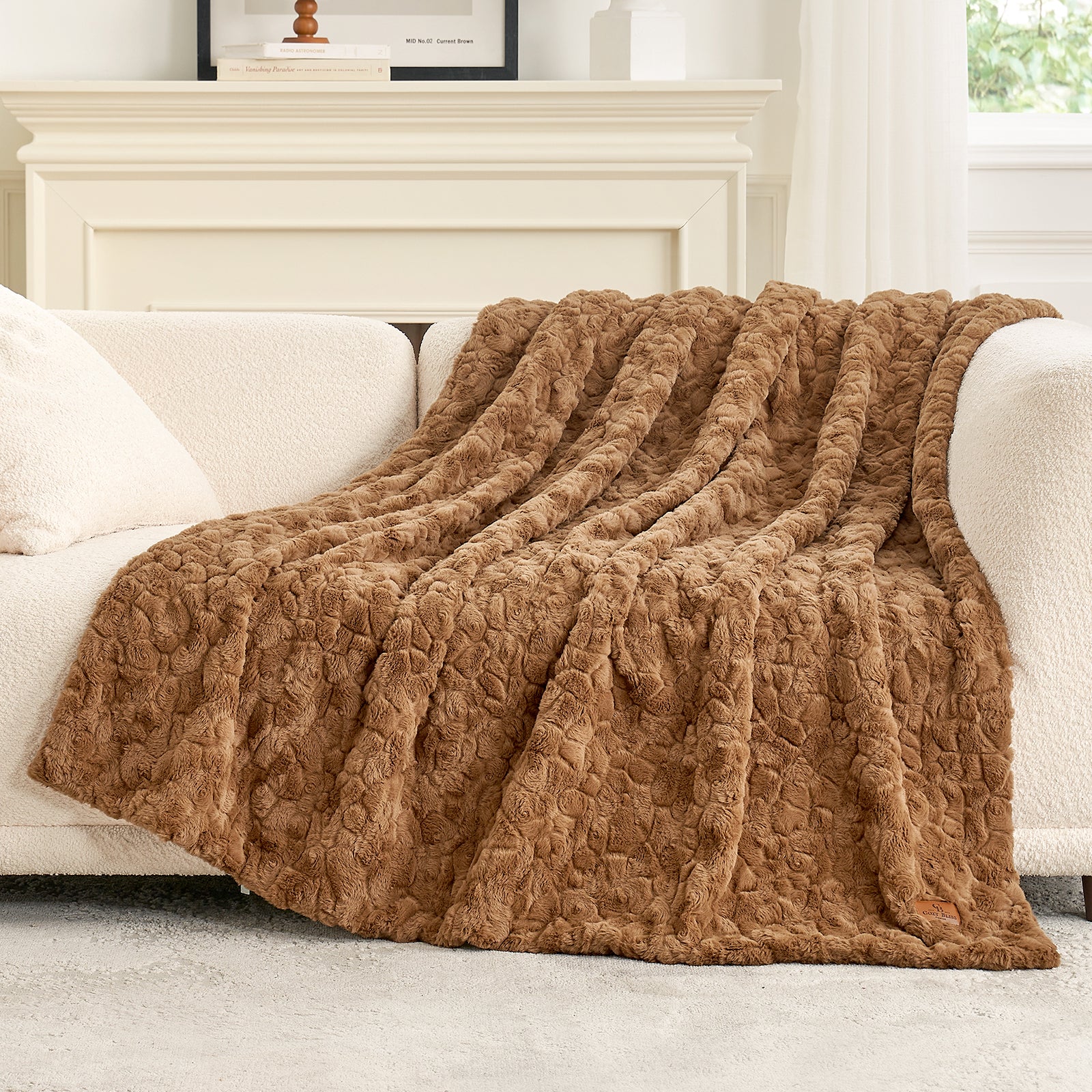 Brown textured blanket draped over a white sofa in a living room setting. #color_Brown