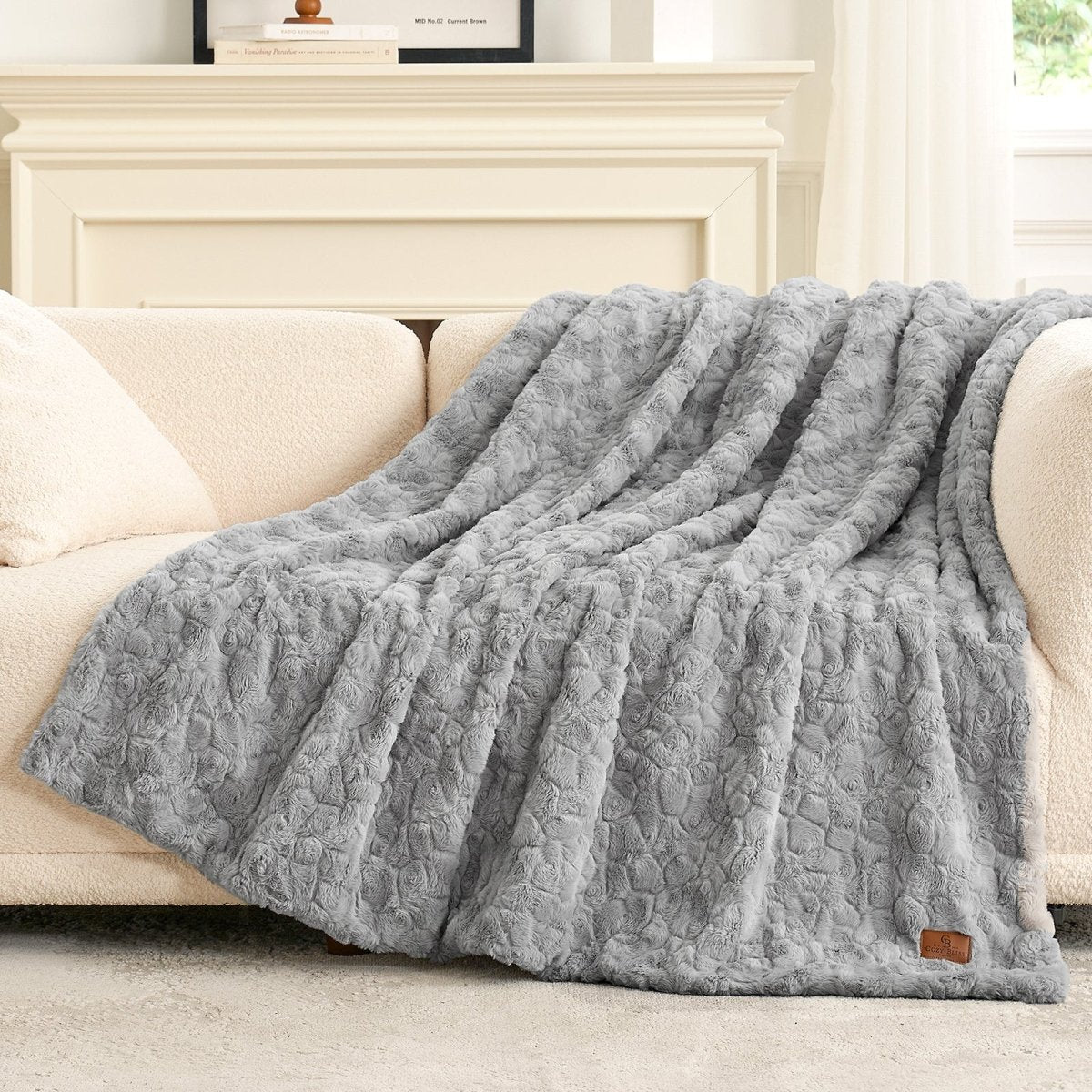 Grey textured blanket on a beige sofa in a living room setting #color_Grey