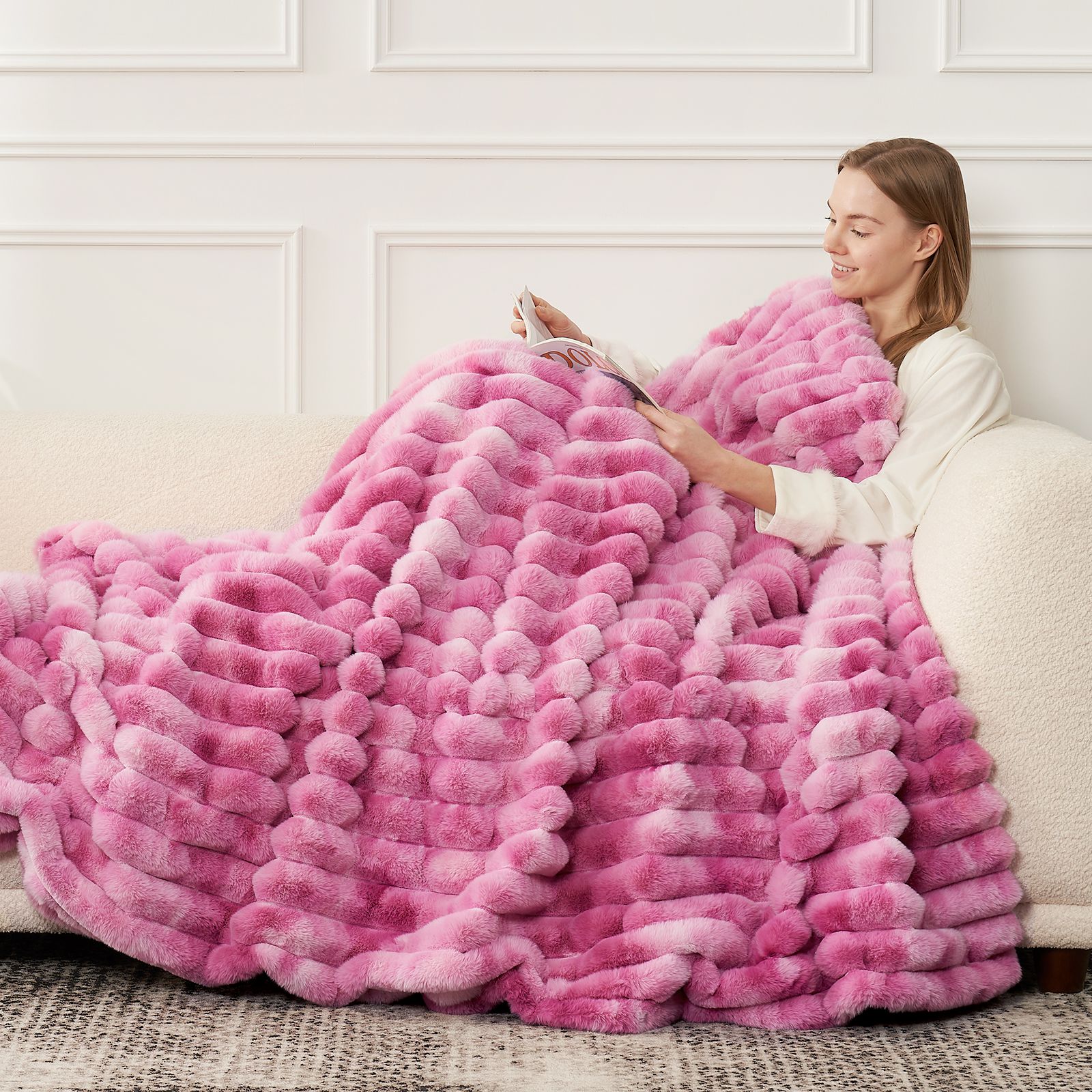 Woman relaxing under pink striped faux fur blanket on sofa. Cozy bedding. #color_Tie-dye Pink