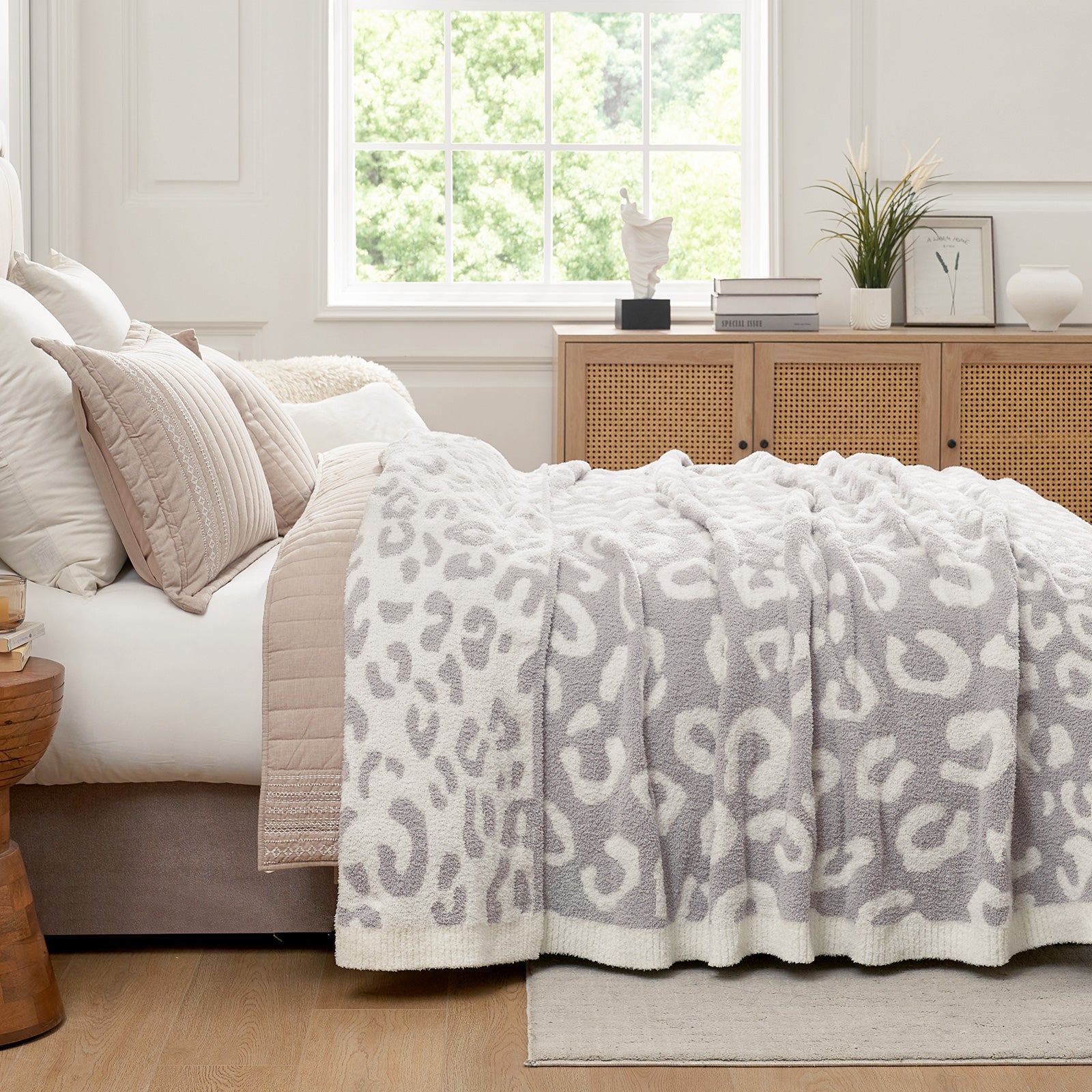 Reversible Leopard Feather Yarn Throw Blanket in Leopard Grey styled on a bed, adding a calm and cozy layered look. #color_Leopard Grey