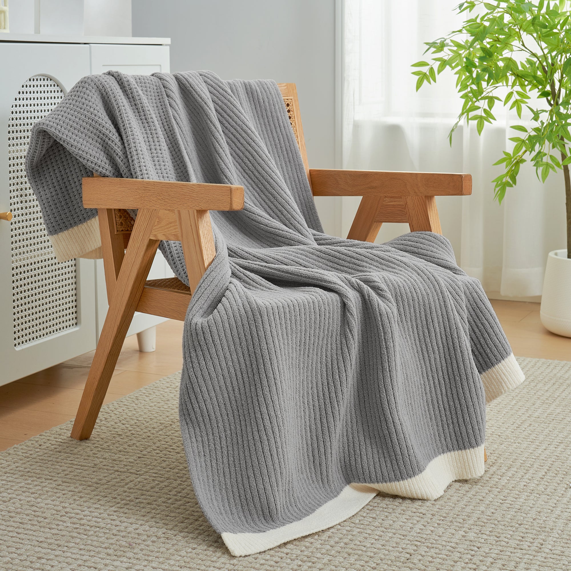 Chenille Waffle Knit Throw Blanket in Grey styled on an armchair, adding a modern and cozy layered look. #color_Grey
