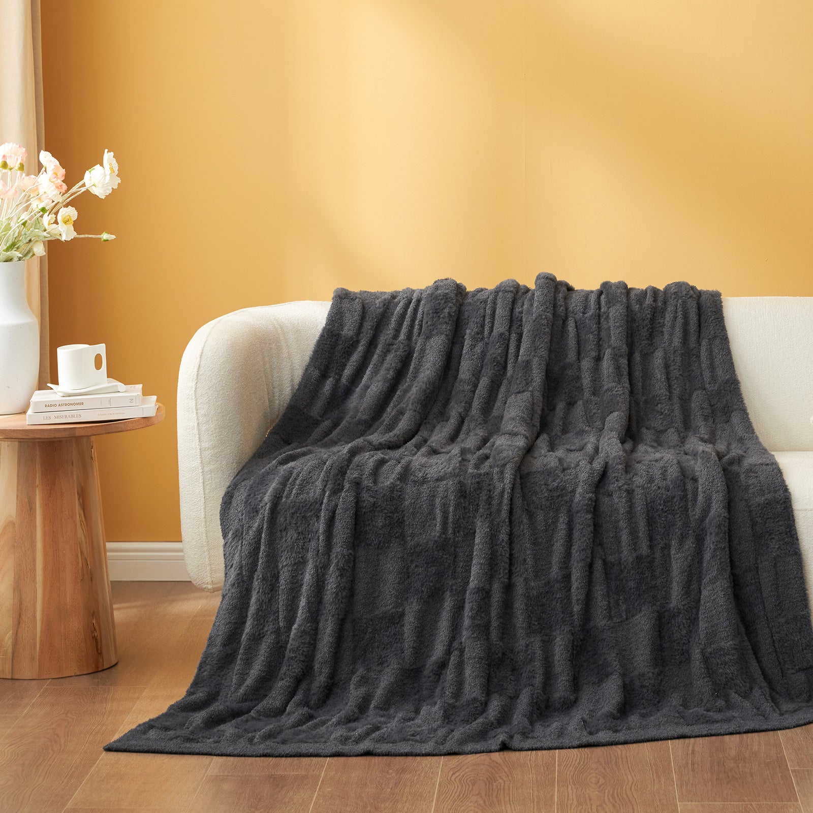 Checkered Faux Fur Feather Yarn Throw Blanket in Dark Grey draped over a sofa, highlighting its sleek look. #color_Dark Grey