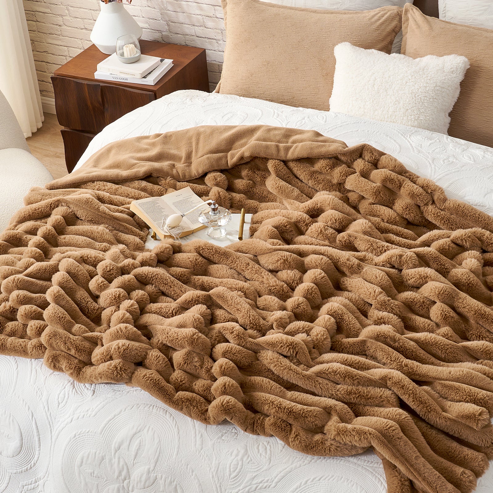Brown textured blanket draped over a bed with pillows and a side table in the background. #color_Toasty Brown