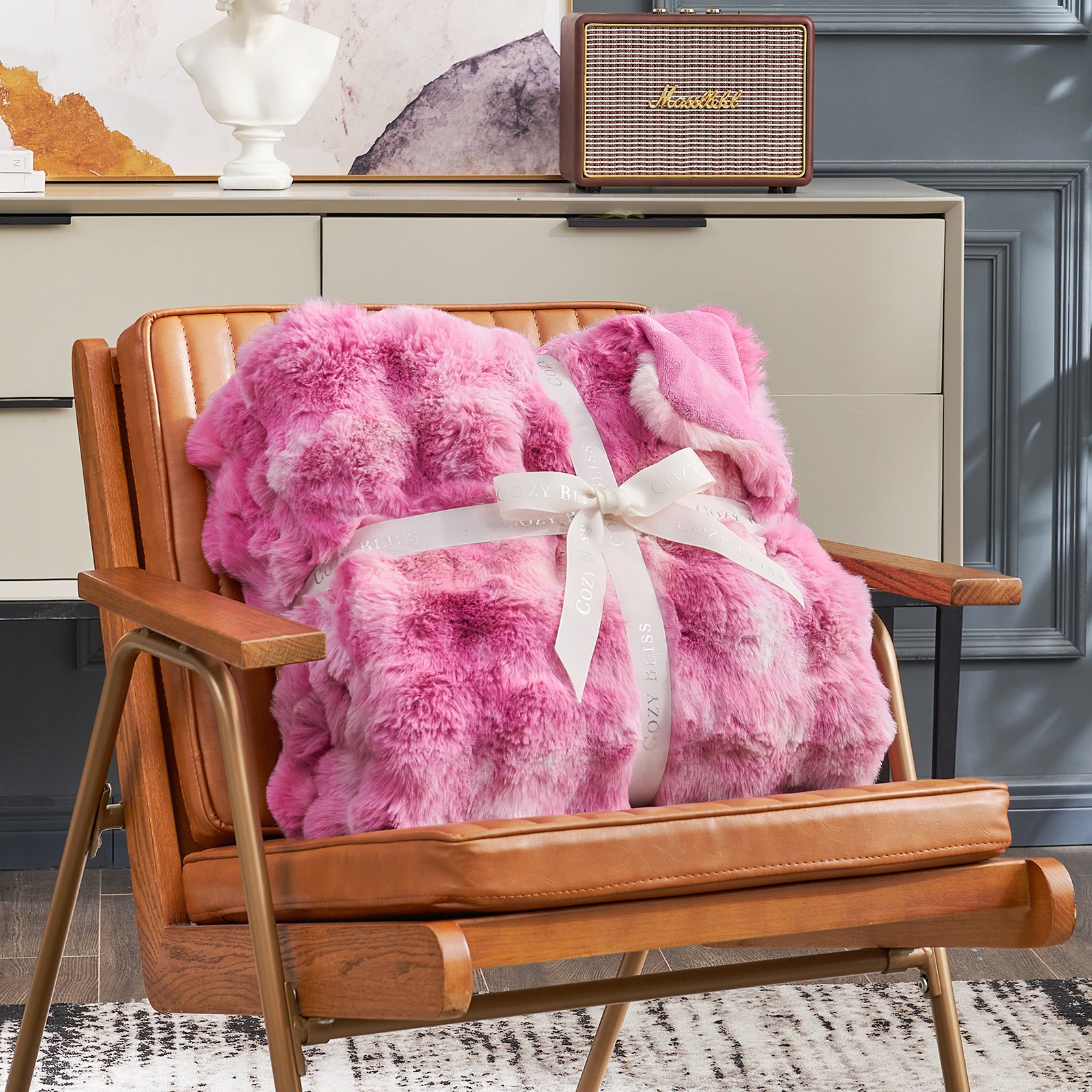 Cozy Bliss pink tie-dye faux fur throw blanket on a brown leather chair, soft and cozy for comfort #color_Tie-dye Pink
