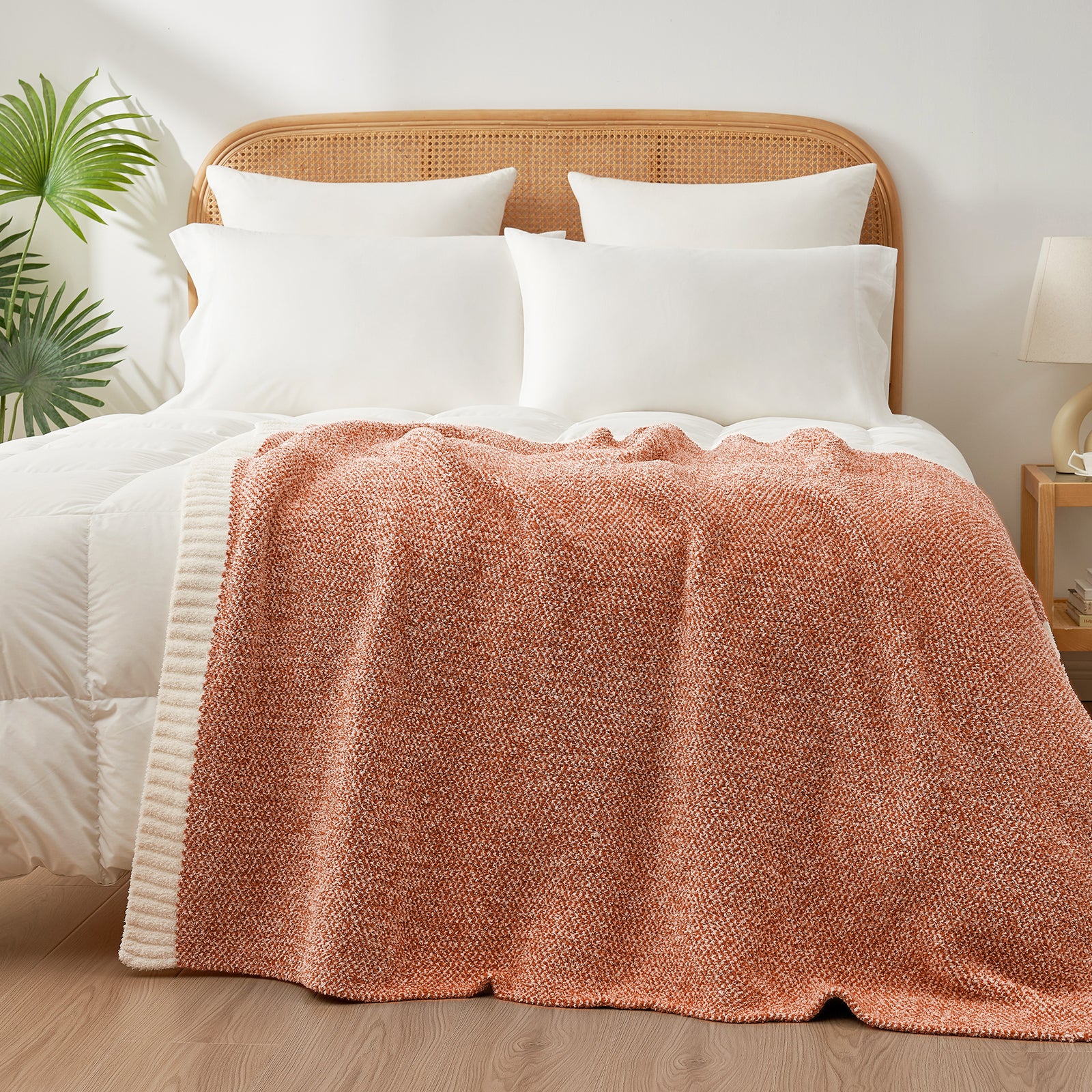 Heather Feather Yarn Throw Blanket in orange styled on a bed, enhancing bedroom decor with a soft, elegant and cozy layered look. #Color_Orange