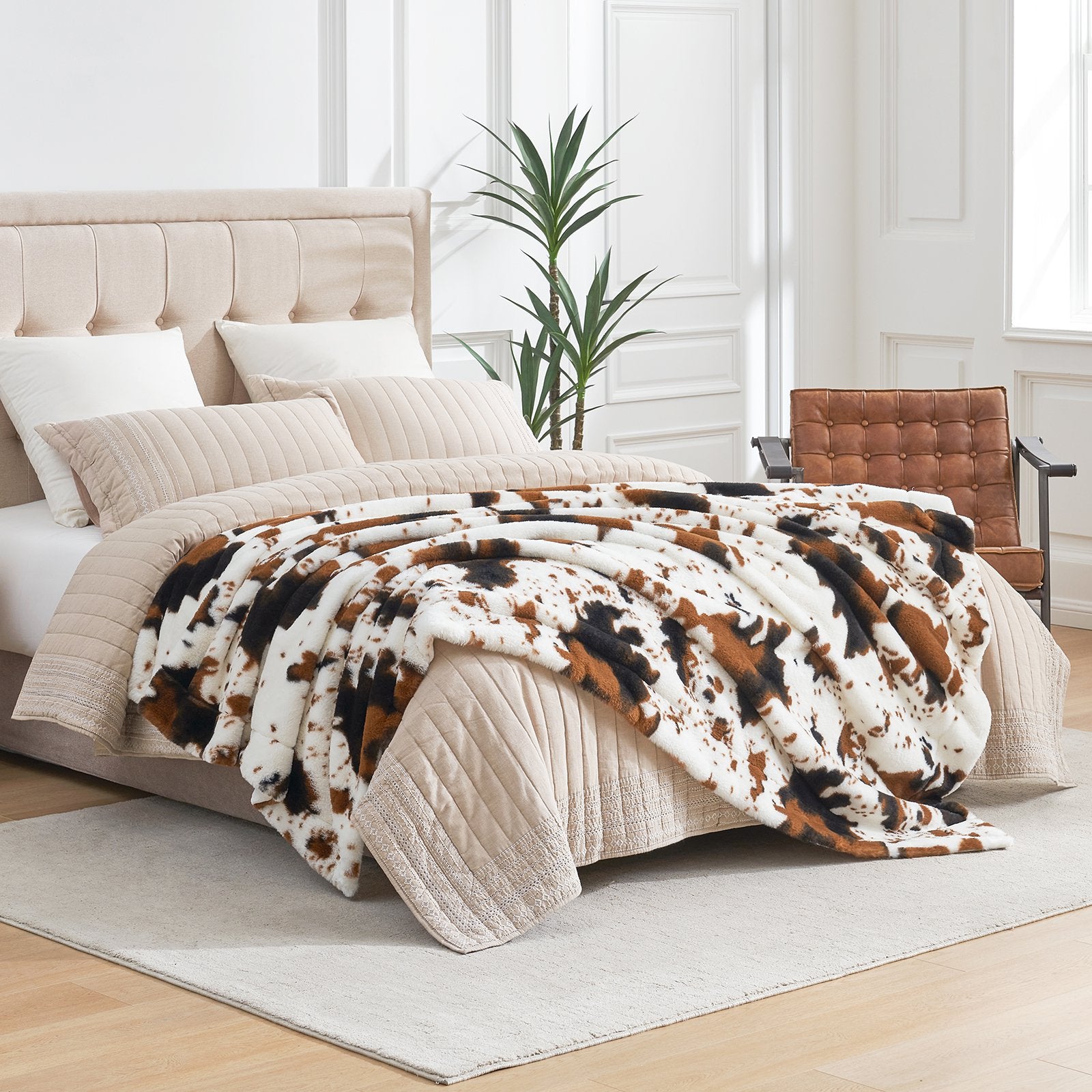 Cow print faux fur blanket on bed, cozy bedding with stylish cow pattern design #color_Black/Brown