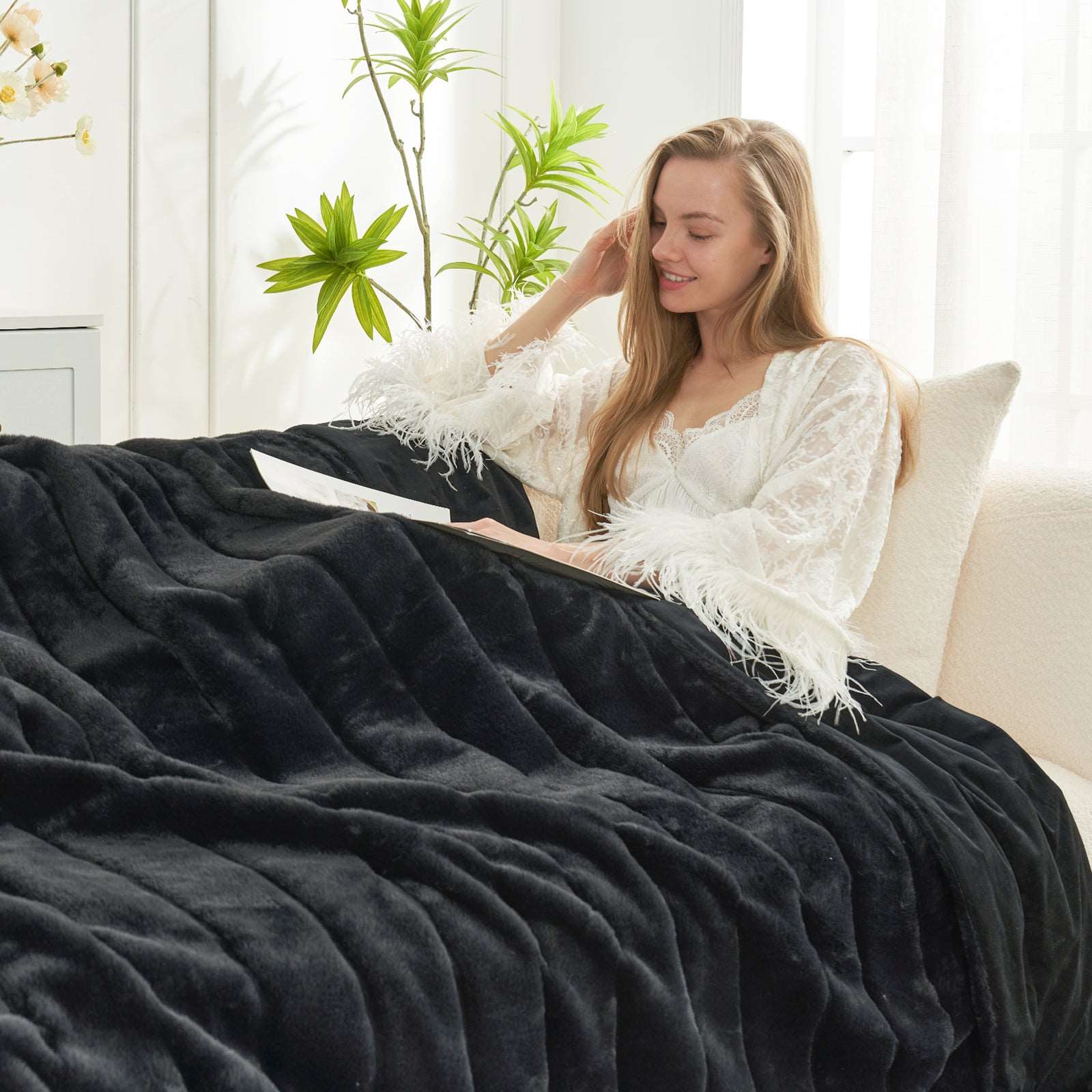 CozyBliss black faux fur throw blanket on a woman relaxing. Ultra-soft, warm, and stylish cozy bedding. #color_Black
