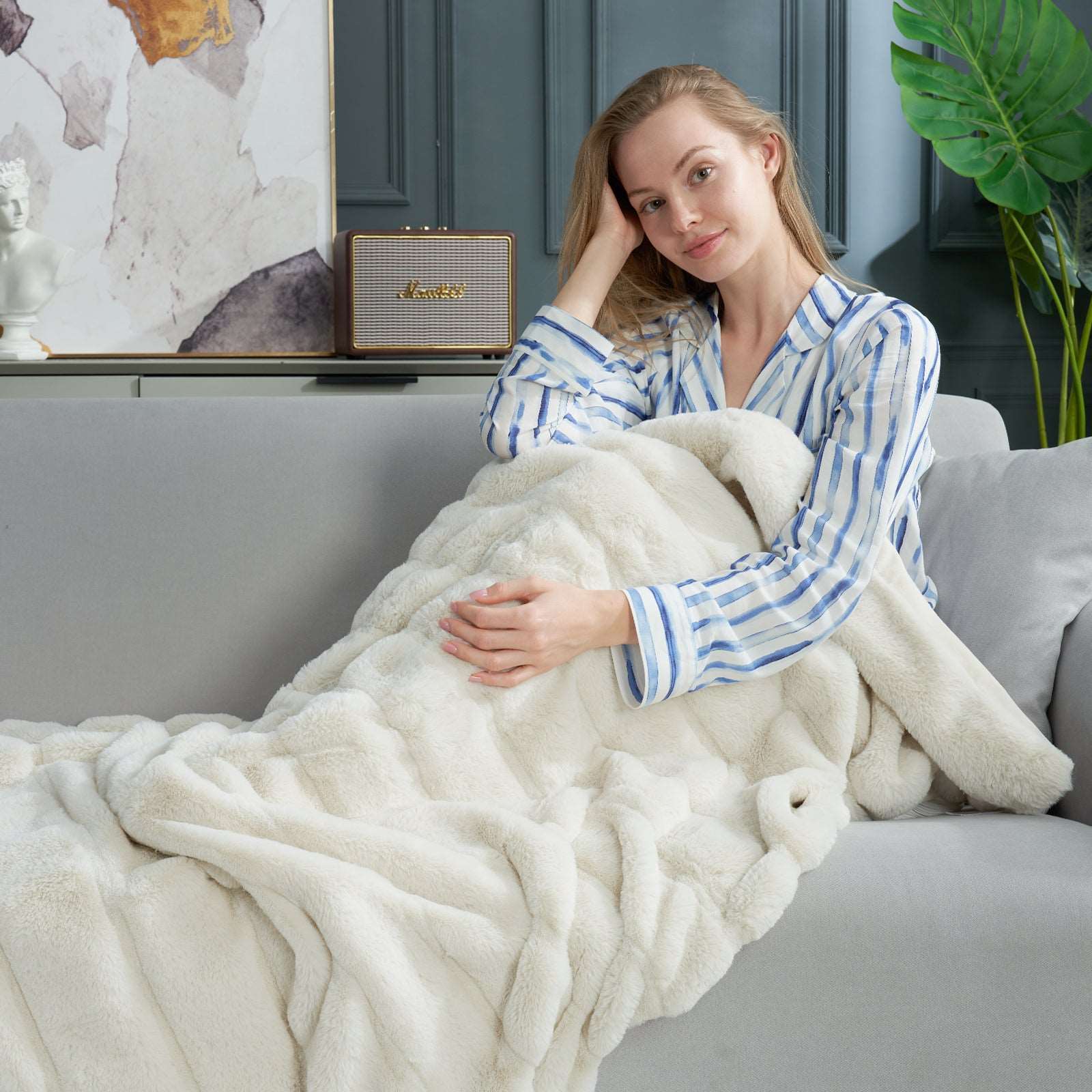 Woman draped in a white CozyBliss faux fur throw blanket, soft and cozy, perfect for home comfort #color_Beige