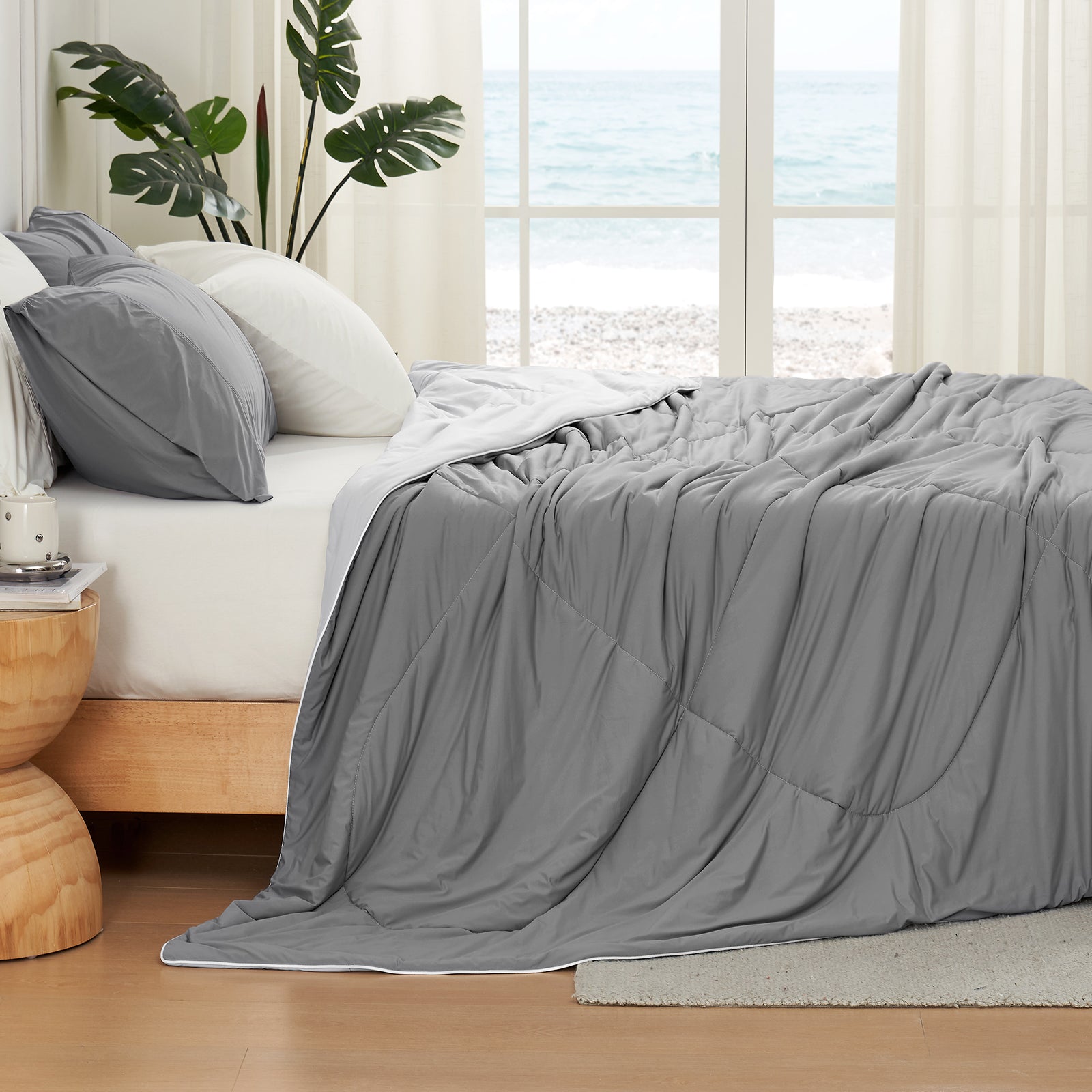 Cozy Bliss gray cooling comforter on bed, breathable bedding for hot sleepers, beach view. #Color_ Dark/Light Grey