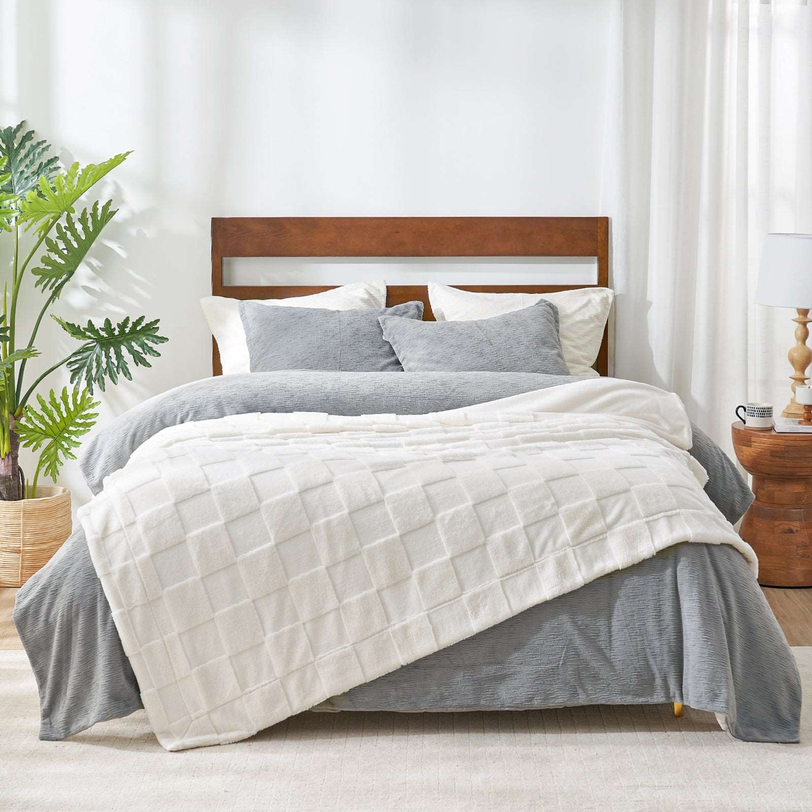 White faux fur checkerboard throw blanket on bed with gray bedding, cozy blanket for home. #color_Ivory