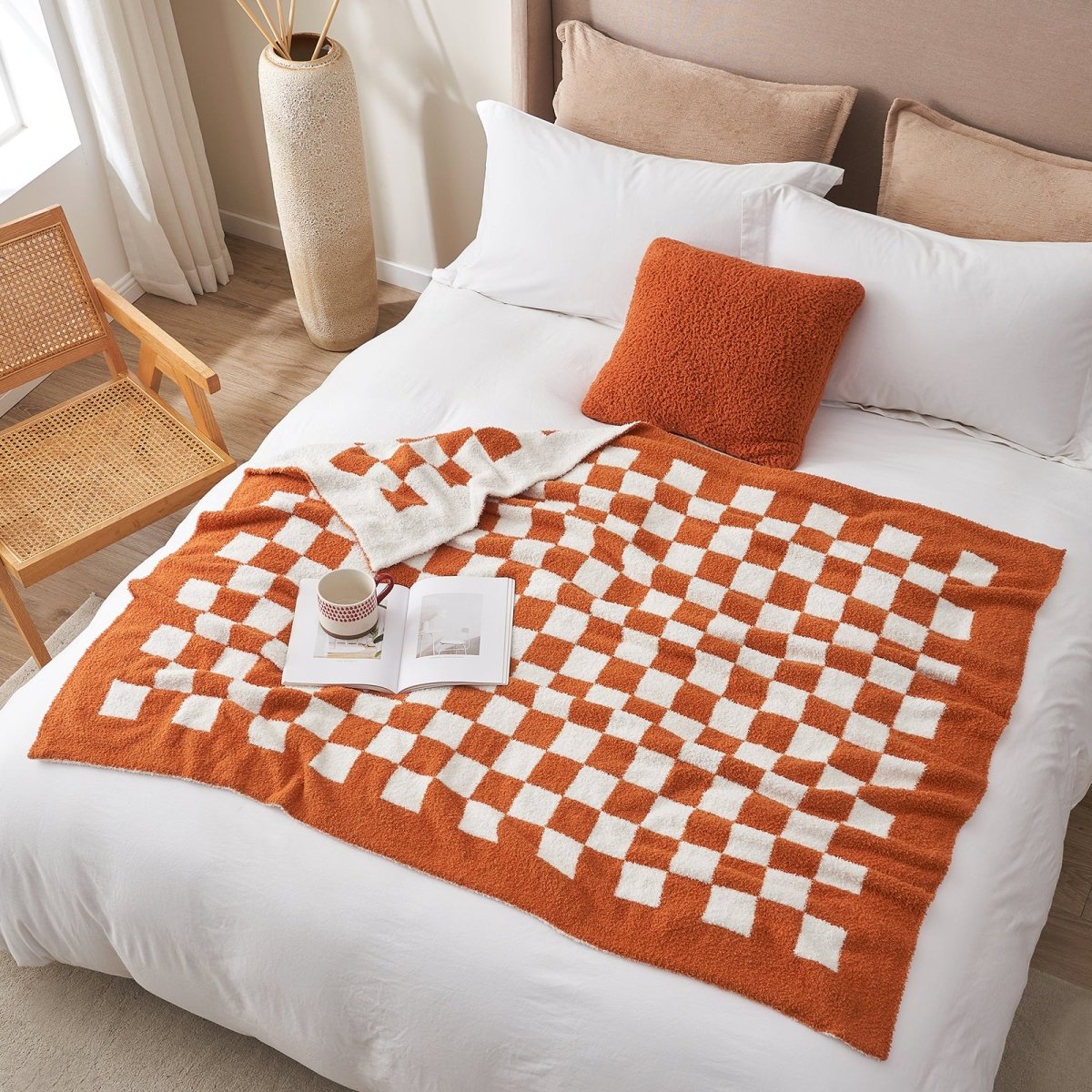 Checkered Feather Yarn Knit Throw Blanket in Burnt Orange styled on a bed in a bright bedroom. #Color_Burnt Orange