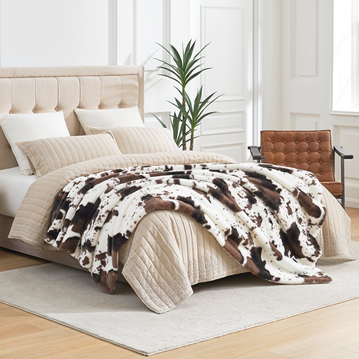 Cozybliss cow print faux fur throw blanket on bed. Luxury bedroom bedding, soft and stylish. #color_Black/Coffee Cow