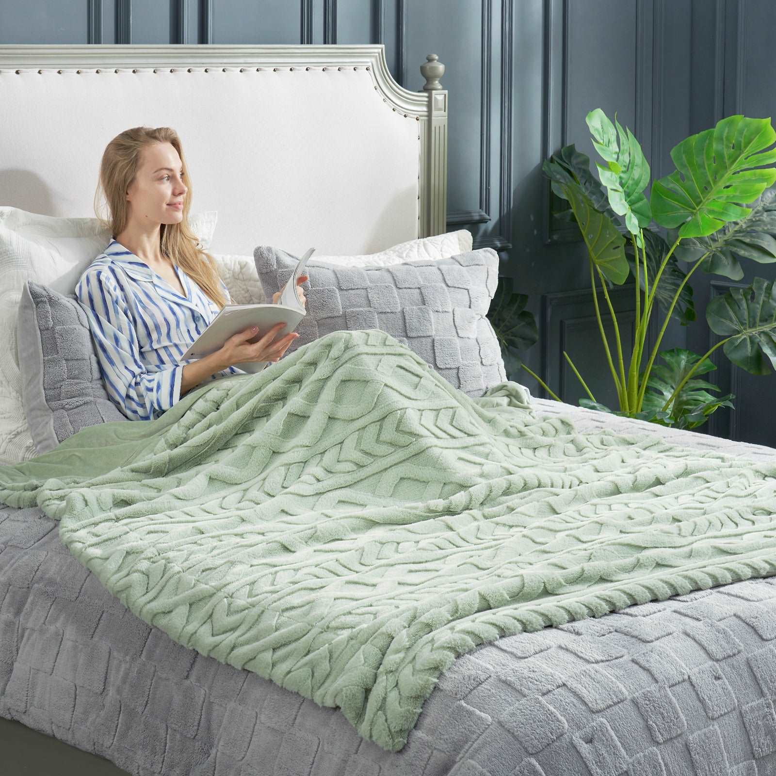 Woman relaxing with Cozy Bliss cable knit blanket #color_Sage Green