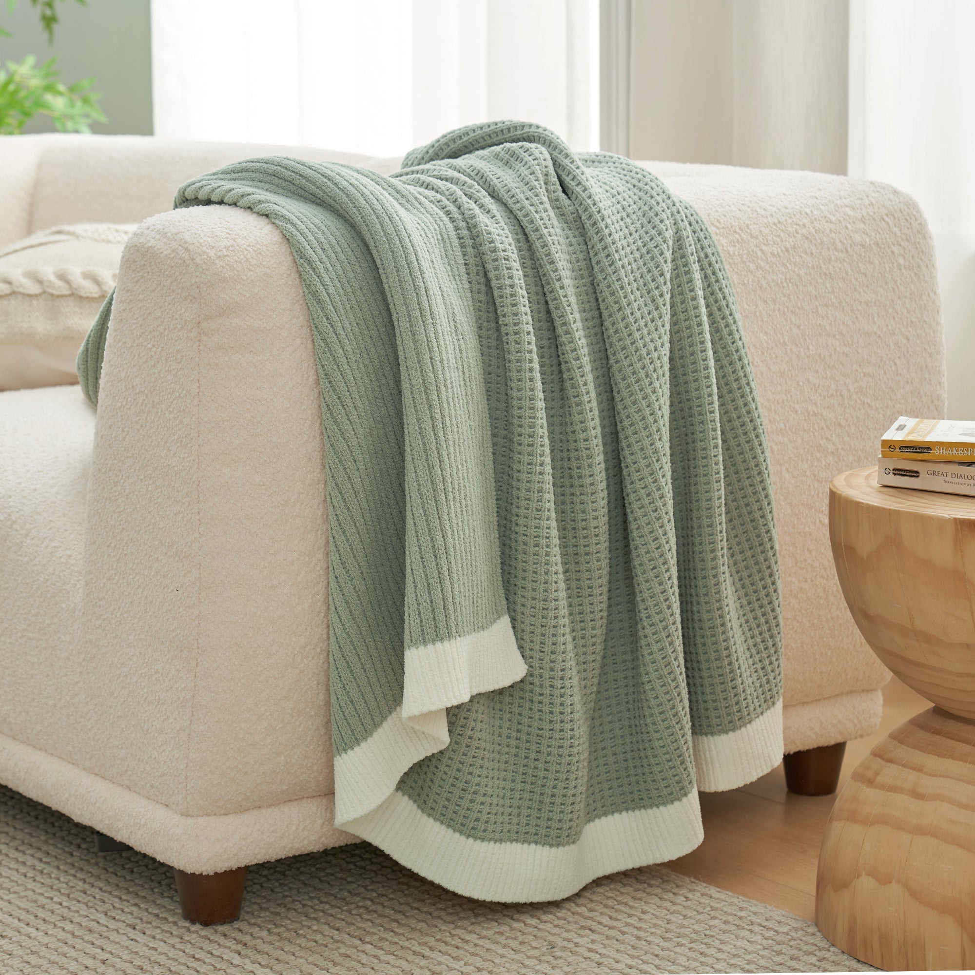 Chenille Waffle Knit Throw Blanket in Sage Green draped over a sofa, showcasing its soft tone and cozy texture. #color_Sage Green