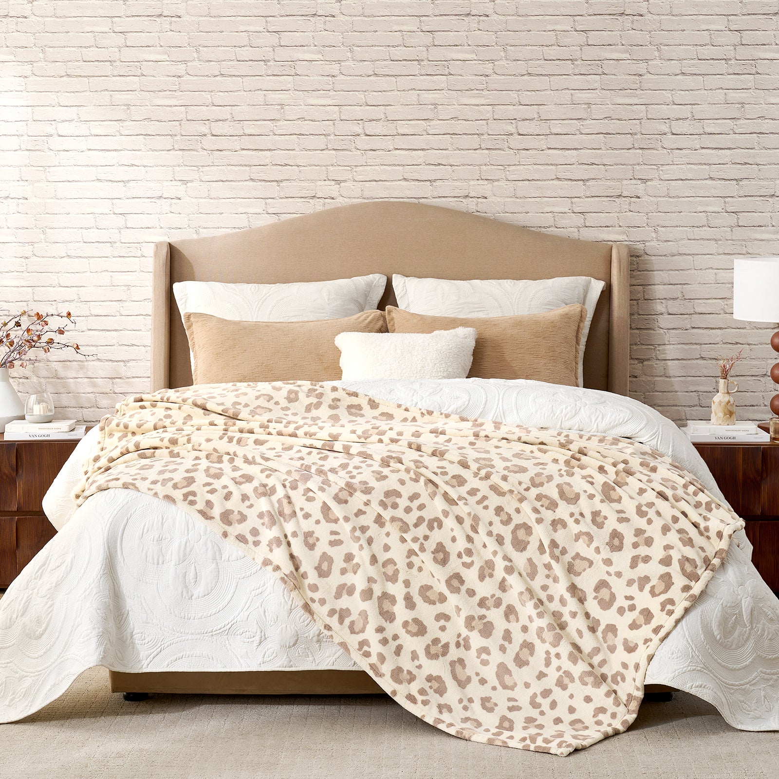 Bed with leopard print blanket and beige headboard against a brick wall. #color_Khaki Leopard