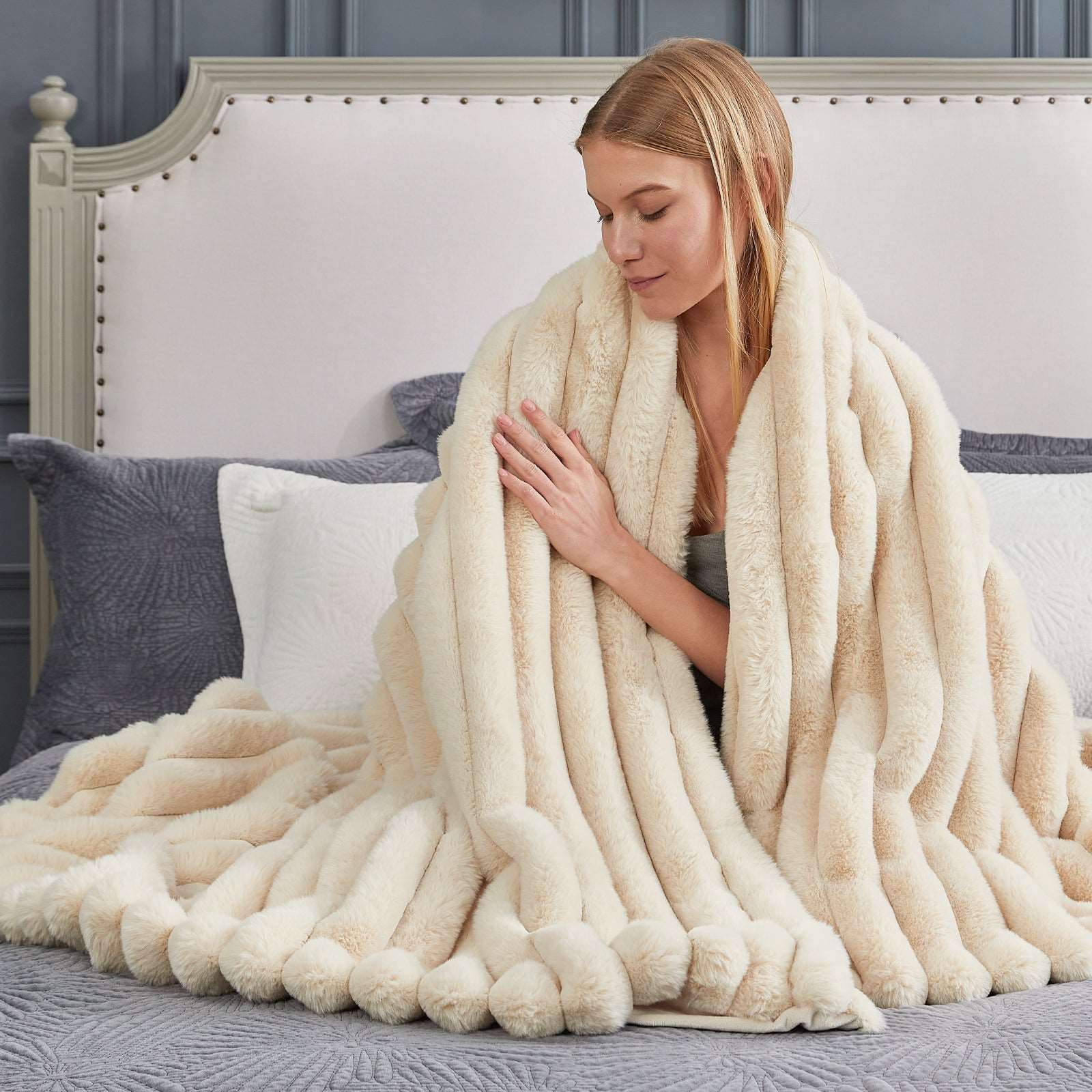 Woman wrapped in a cozy, cream faux fur blanket #color_Beige