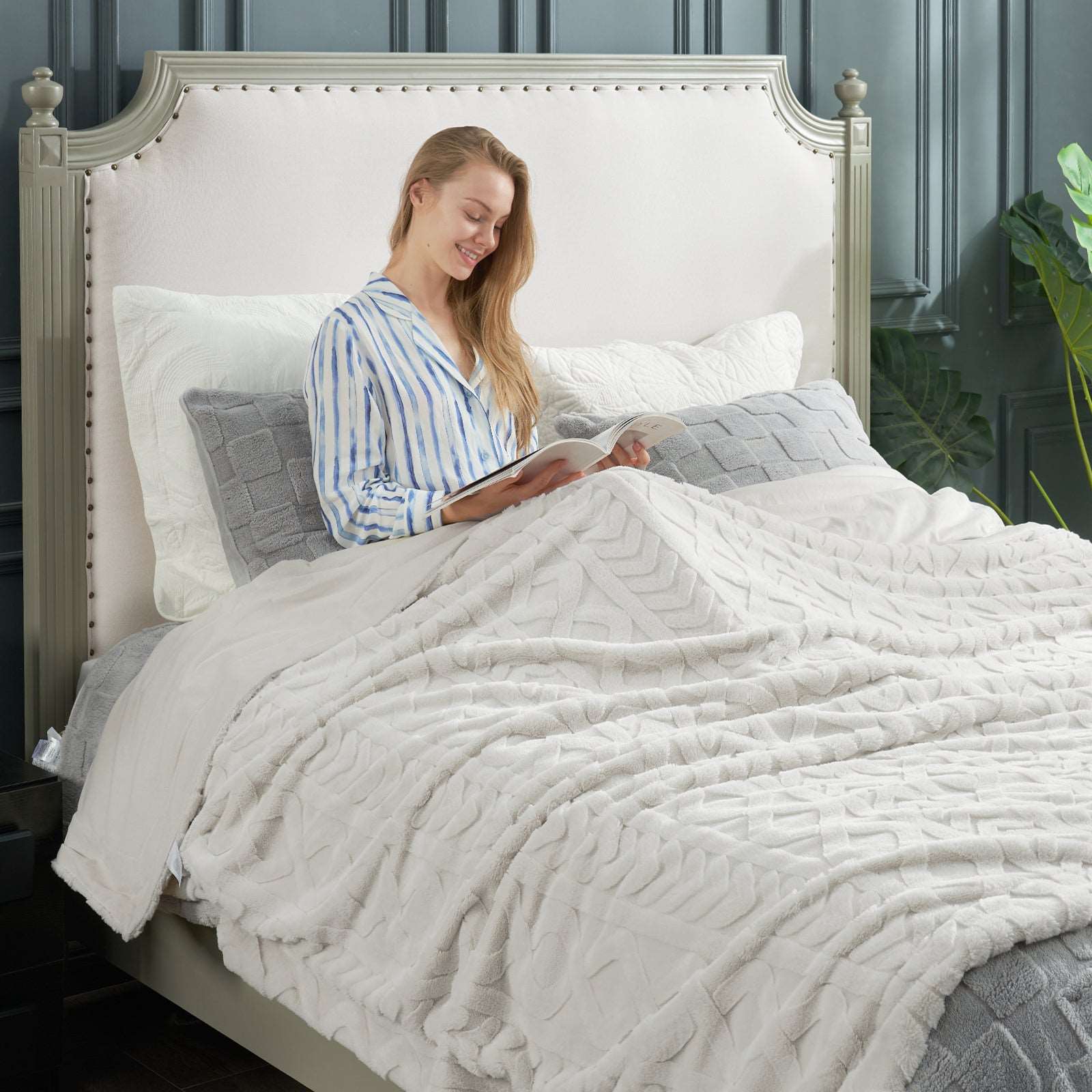 Woman reading under white faux fur blanket, cozy bedding, soft blanket #color_Beige