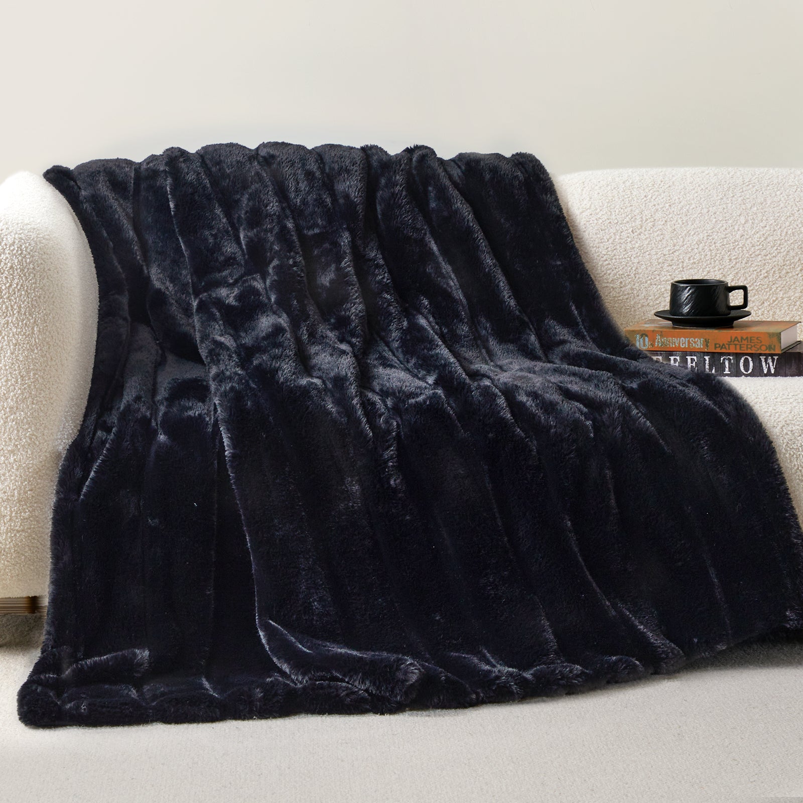 CozyBliss black faux fur throw blanket on a woman relaxing. Ultra-soft, warm, and stylish cozy bedding. #color_Black
