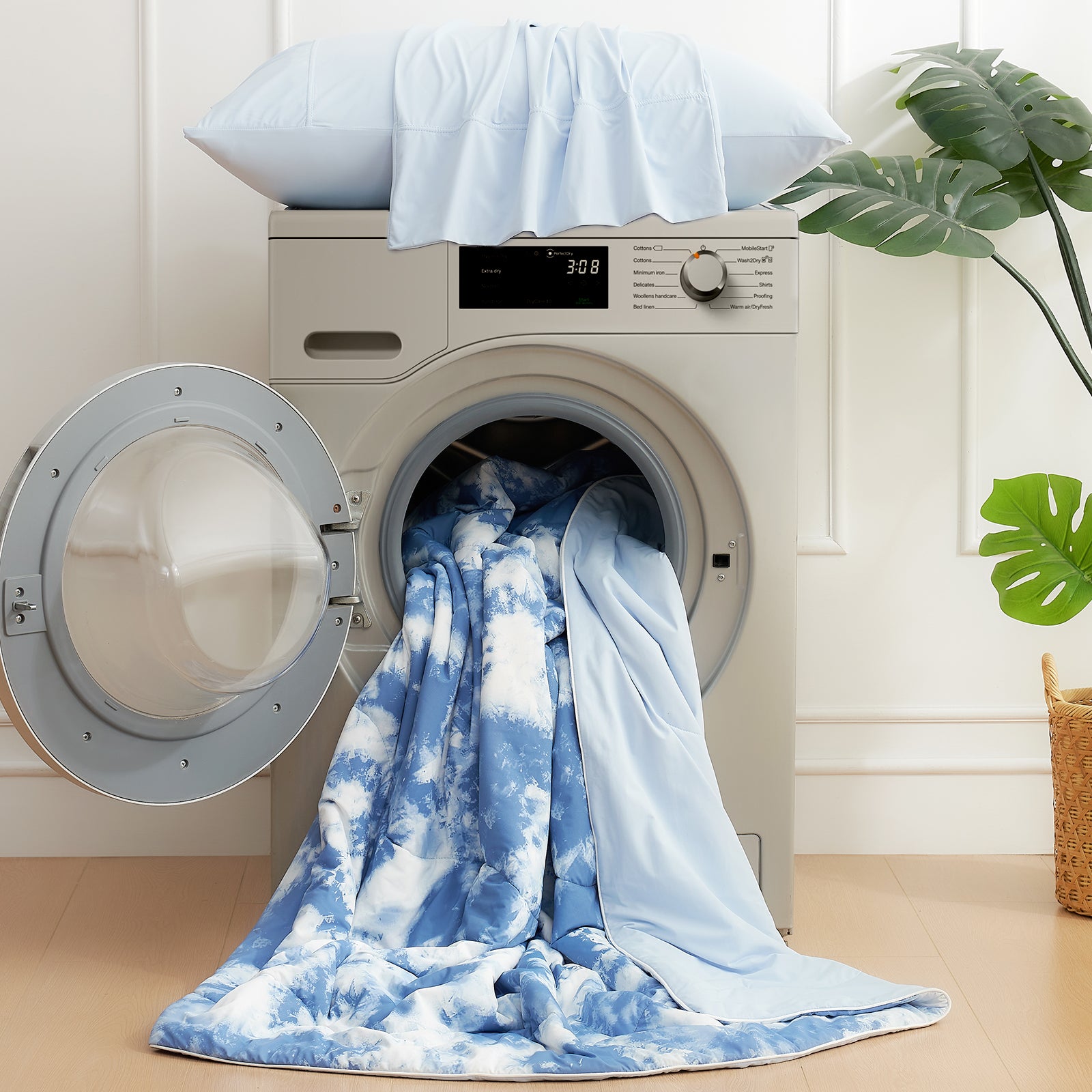 Washing machine with blue and white towels on a light wooden floor. #Color_Tie-dye Blue