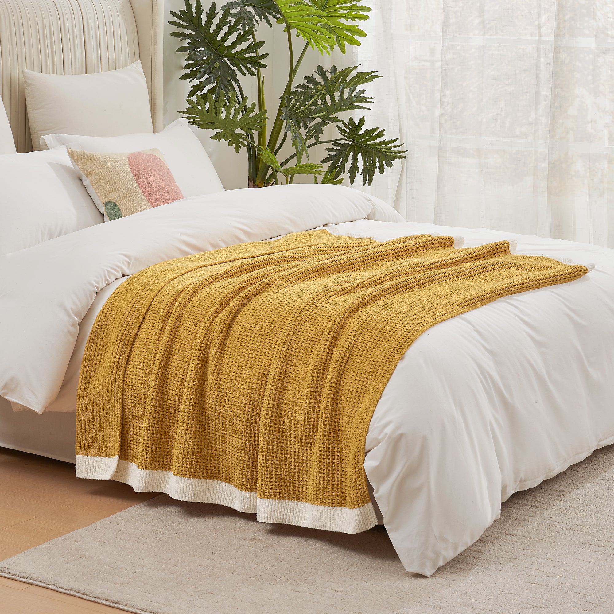 Chenille Waffle Knit Throw Blanket in Yellow draped over a bed, creating a warm feel. #color_Yellow