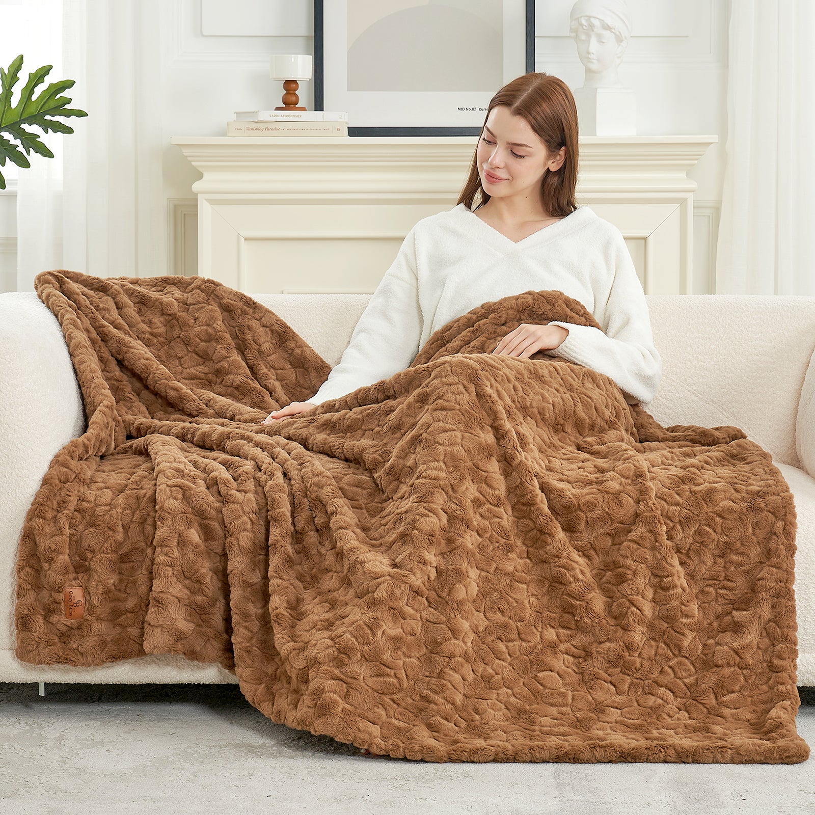Woman sitting on a couch with a brown textured blanket draped over her #color_Brown