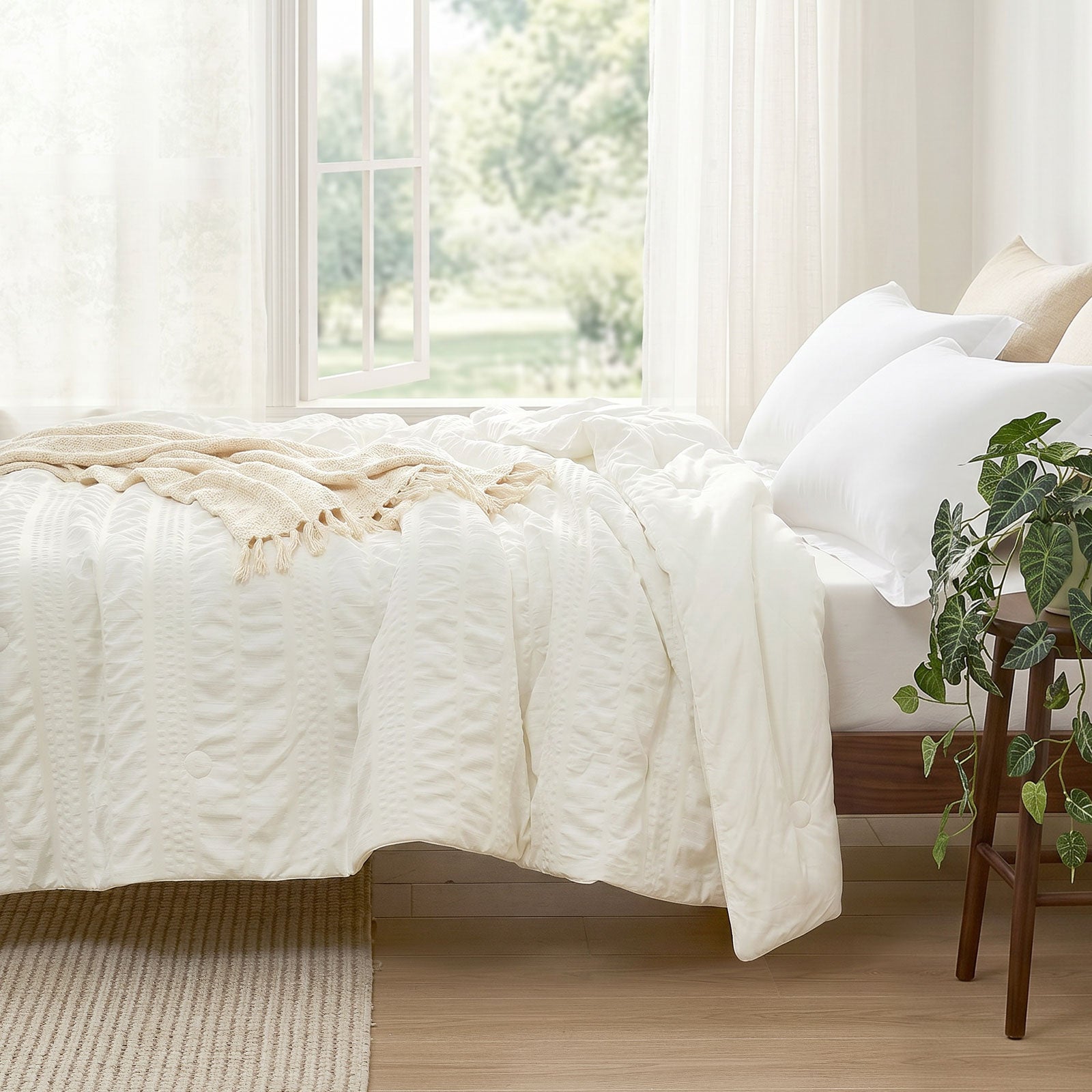 Cozy Bliss seersucker cooling comforter on bed in side view.#color_Cream White