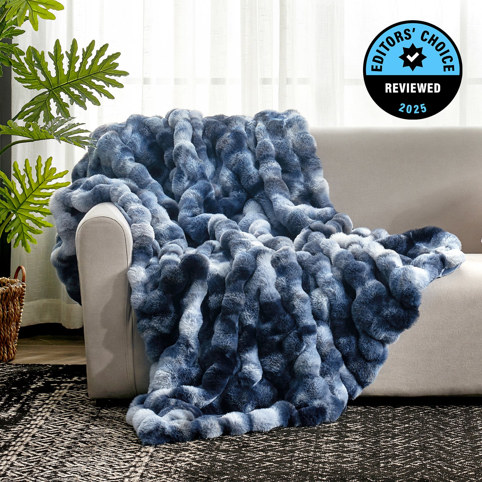 Blue textured blanket draped over a white couch with a plant and rug in the background, featuring an 'Editors' Choice' badge. #Color_Tie-dye Blue