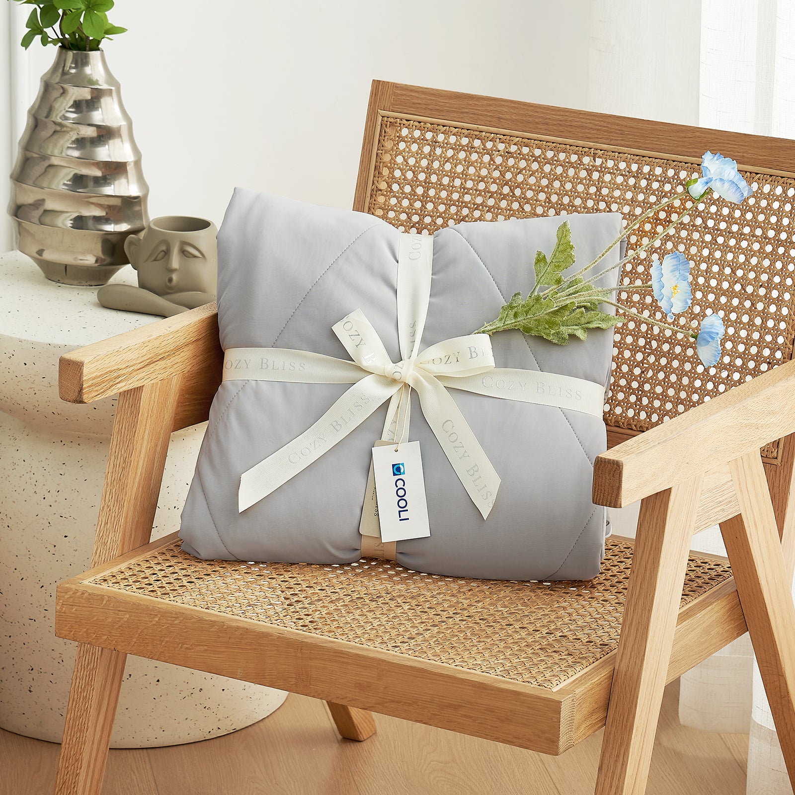 Cozy Bliss cooling comforter, perfect gift wrapped on chair #Color_Grey