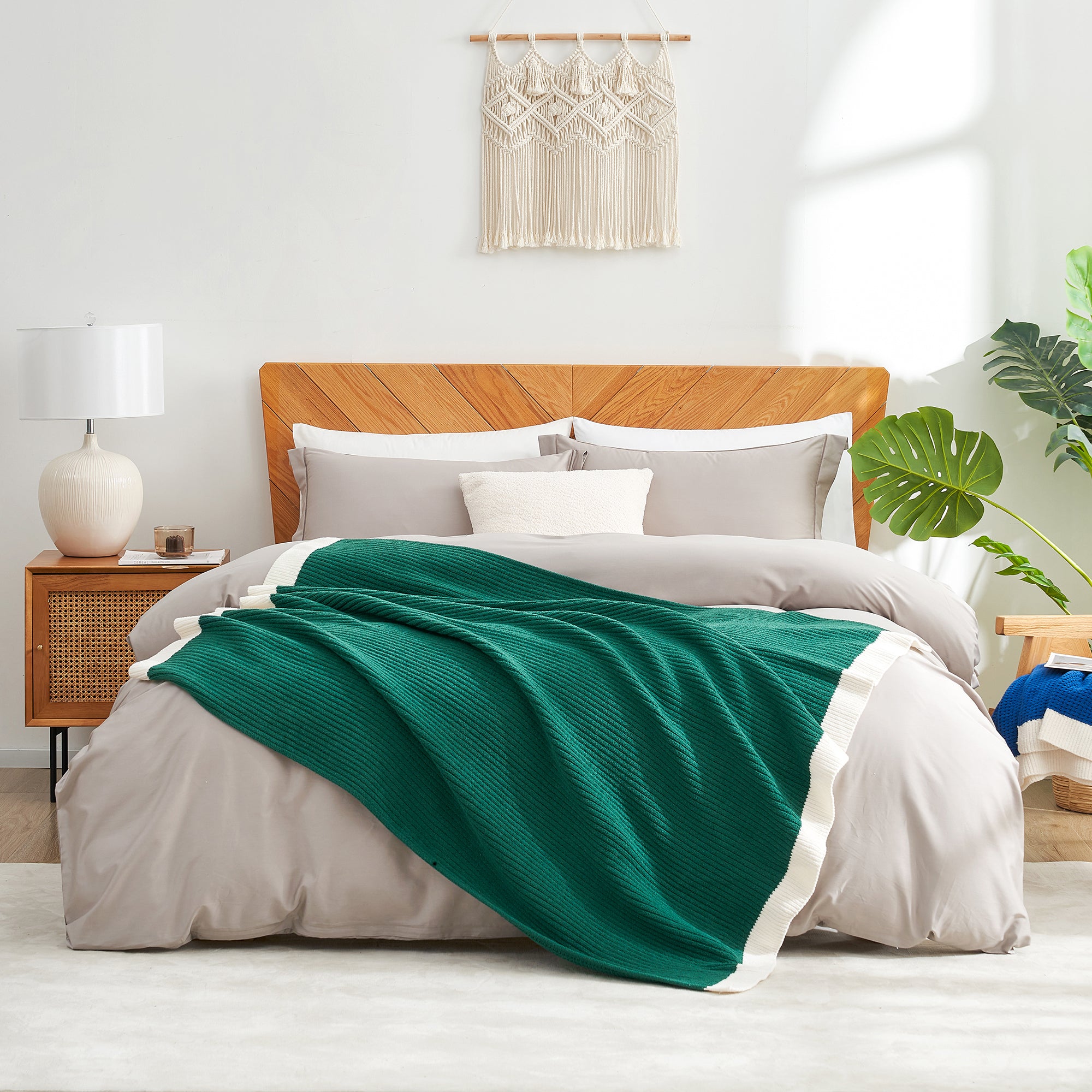 Bedroom with a wooden headboard, green blanket, and white bedding. #color_Green