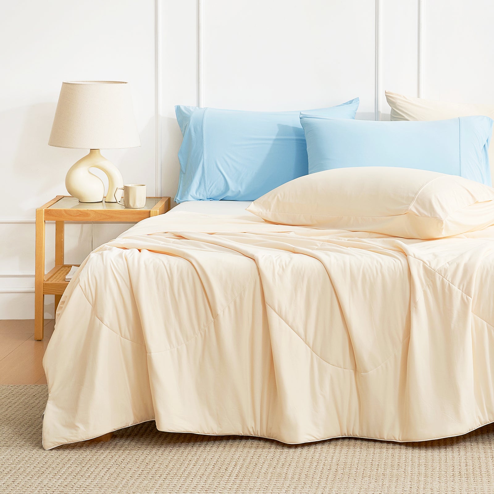 Light beige Cozy Bliss cooling comforter on bed with blue pillows, perfect for hot sleepers #Color_Yellow
