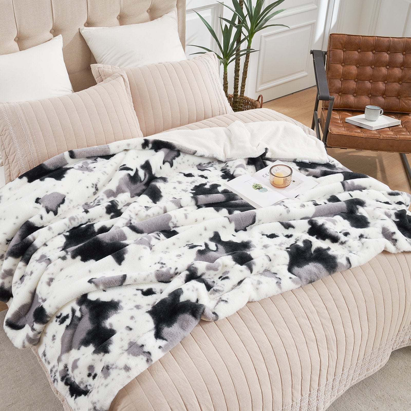 Cow print faux fur blanket, soft and cozy, ideal for layering on bed. Featuring black, white, gray design. #color_Black/Grey