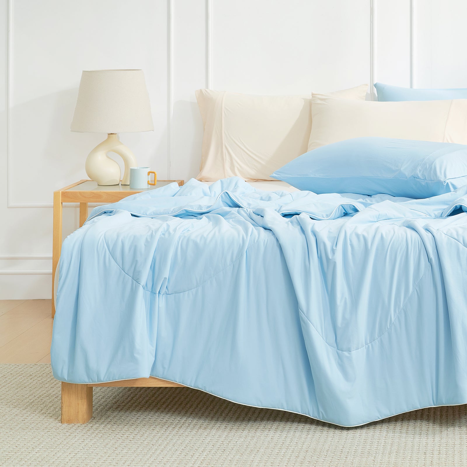 Light blue Cozy Bliss cooling comforter on bed, breathable bedding for hot sleepers, with pillows #Color_Sky Blue