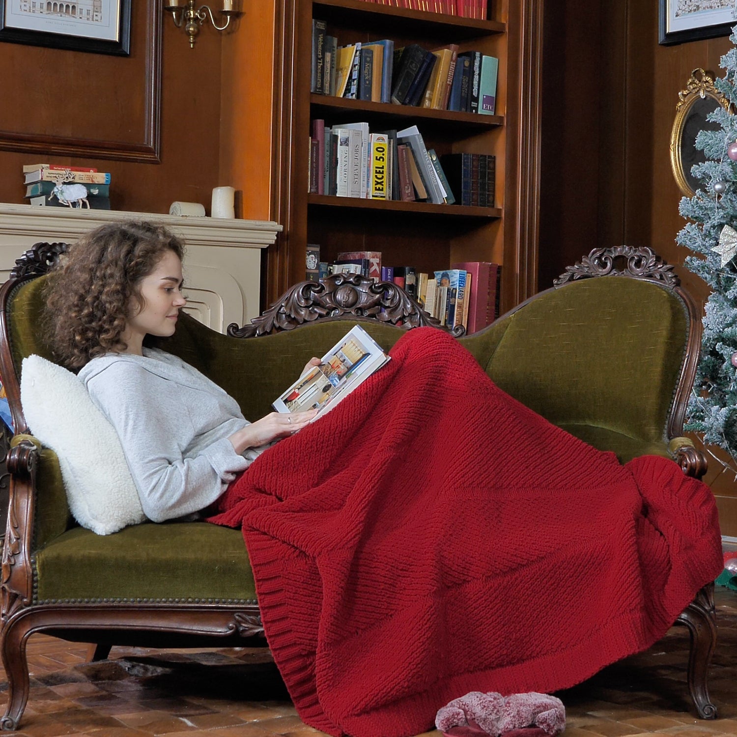 Woman relaxing on a sofa with a Chevron Chenille Knit Throw Blanket in red, ideal for cozy moments. #color_Christmas Red