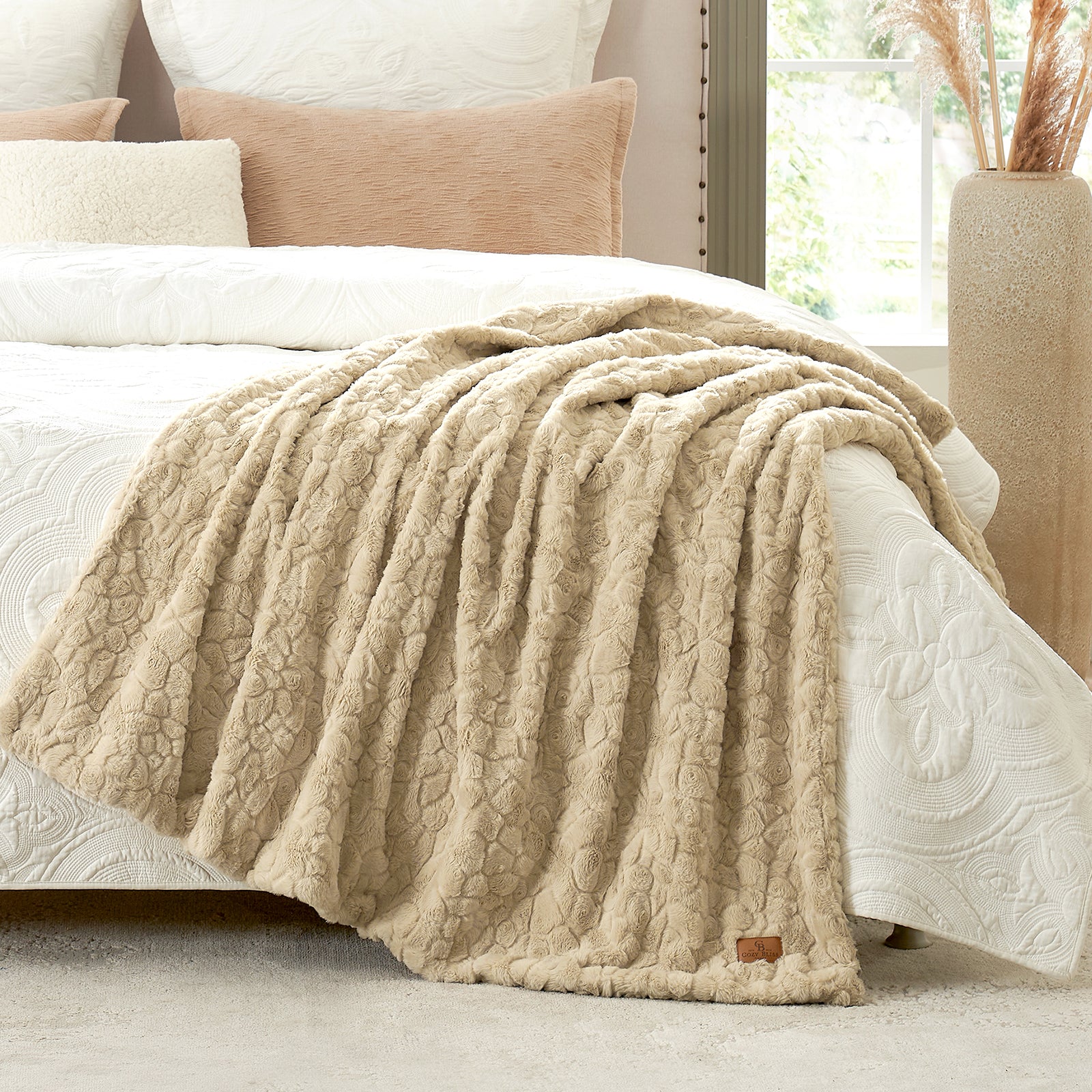 Beige textured blanket draped over a bed with pillows in a cozy bedroom setting. #color_Khaki