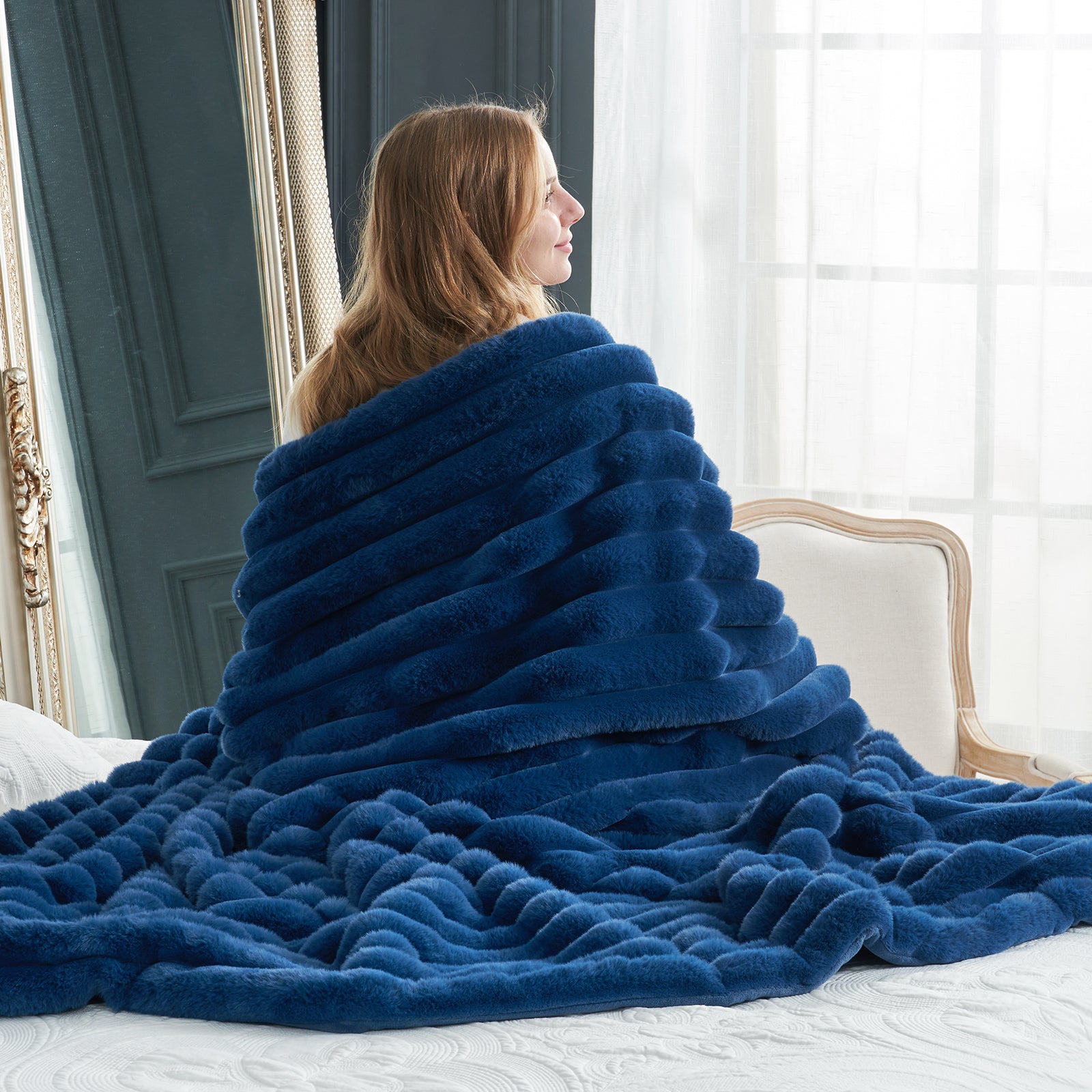 Woman draped in a cozy blue faux fur blanket, perfect for adding warmth. Cozy bedding, soft blanket. #color_Navy Blue