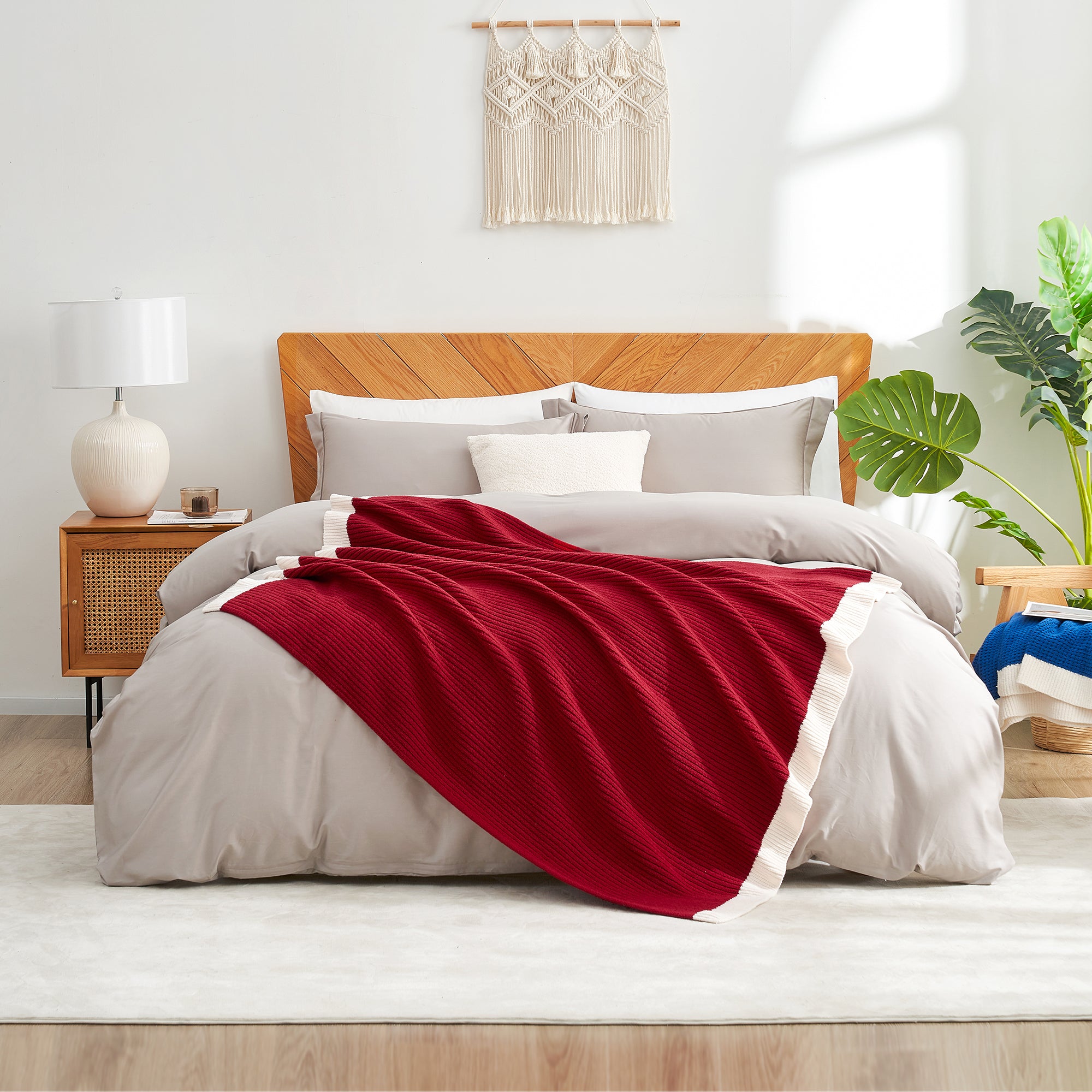 Bedroom with a wooden bed, red blanket, and white pillows. #color_Red