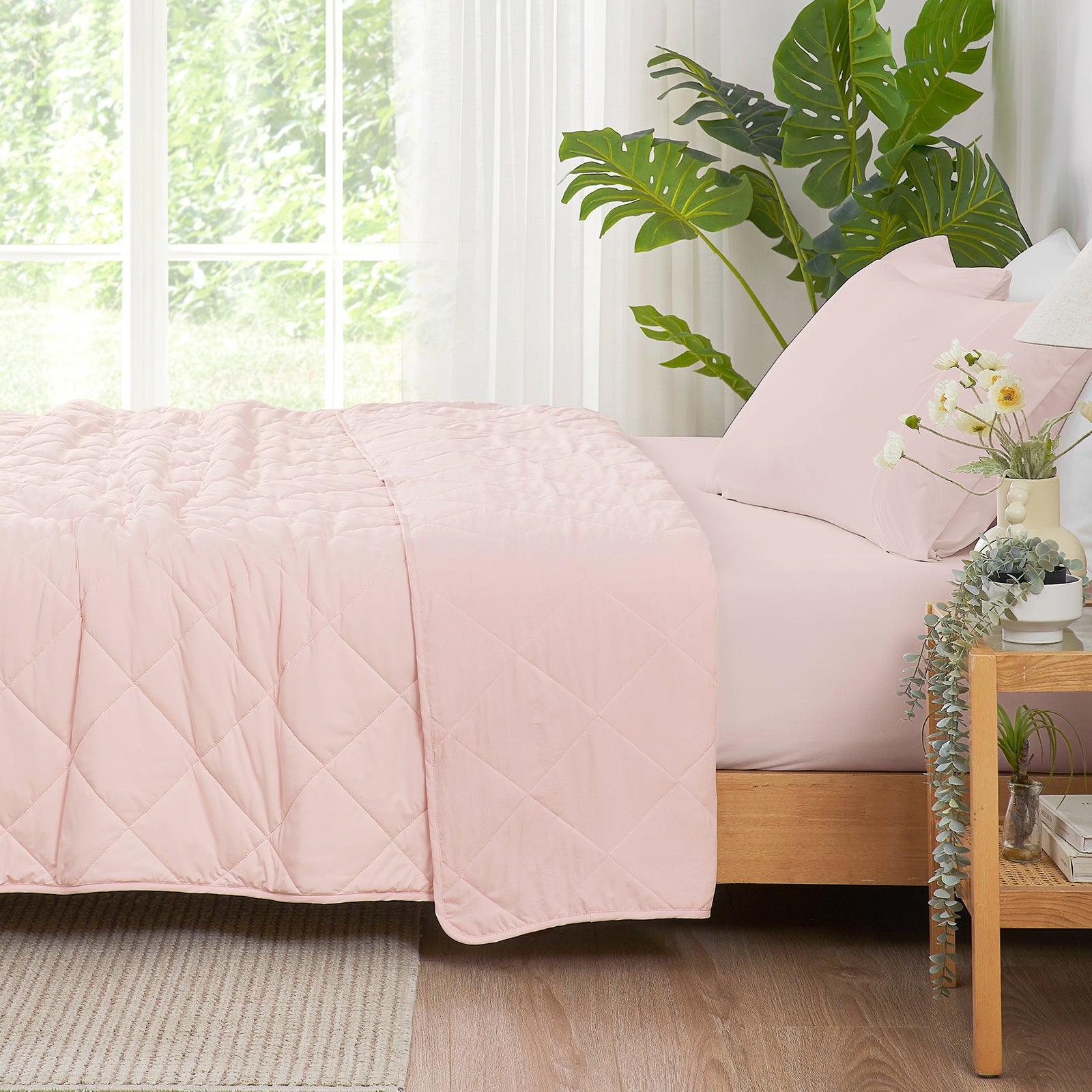 Side View of Cool pink Cozy Bliss Airflow Breathable Cooling Blanket draped on bed. #Color_Cool Pink