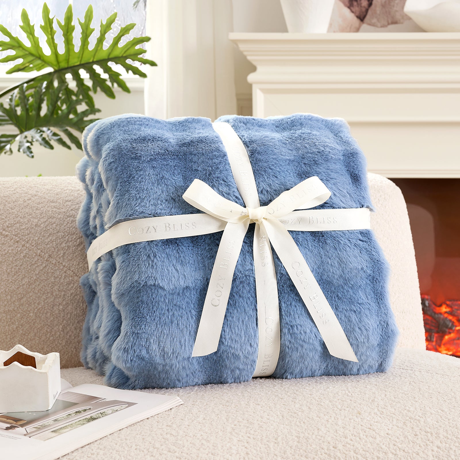Fluffy misty blue blanket with a bow on a armchair. #Color_ Misty Blue