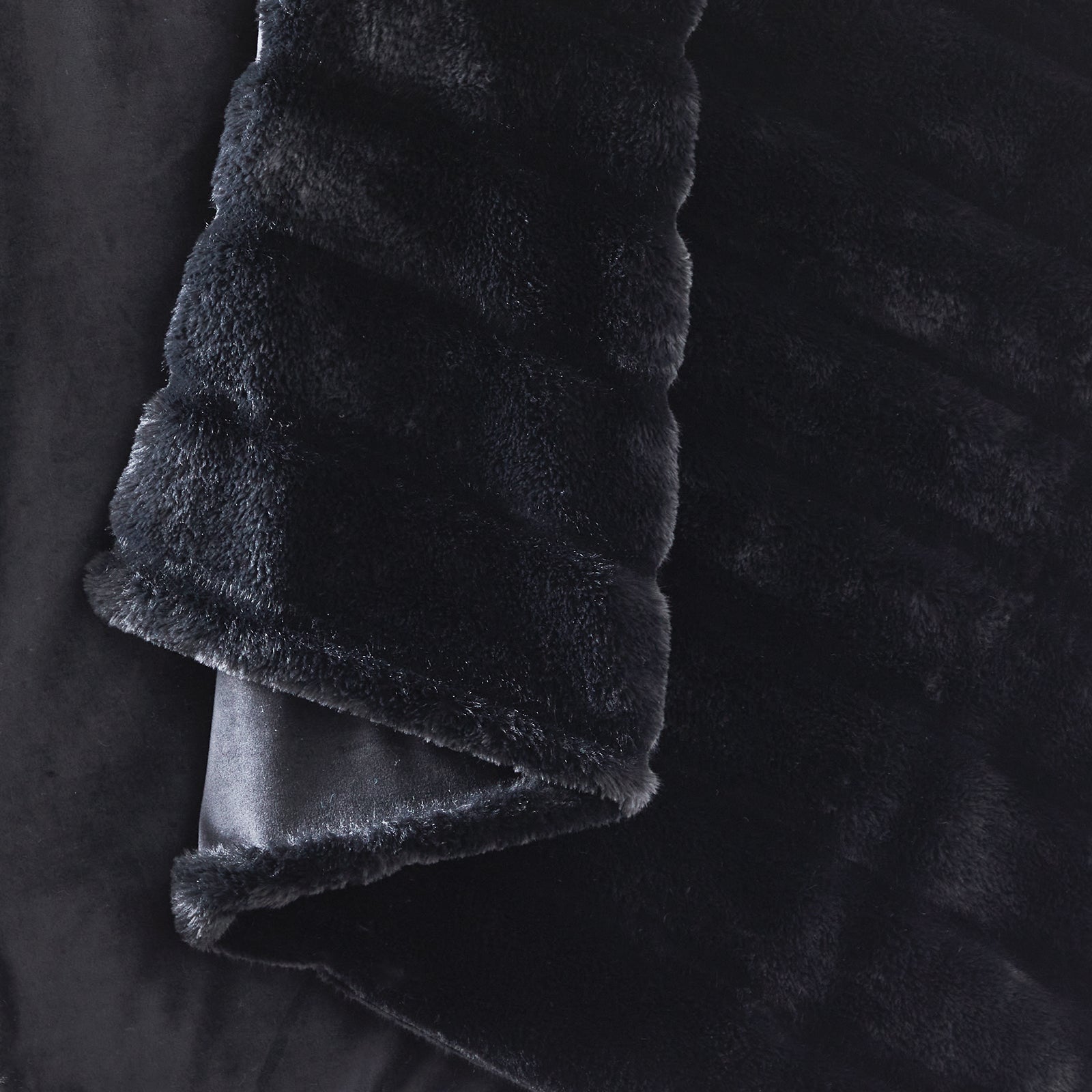 CozyBliss black faux fur throw blanket on a woman relaxing. Ultra-soft, warm, and stylish cozy bedding. #color_Black