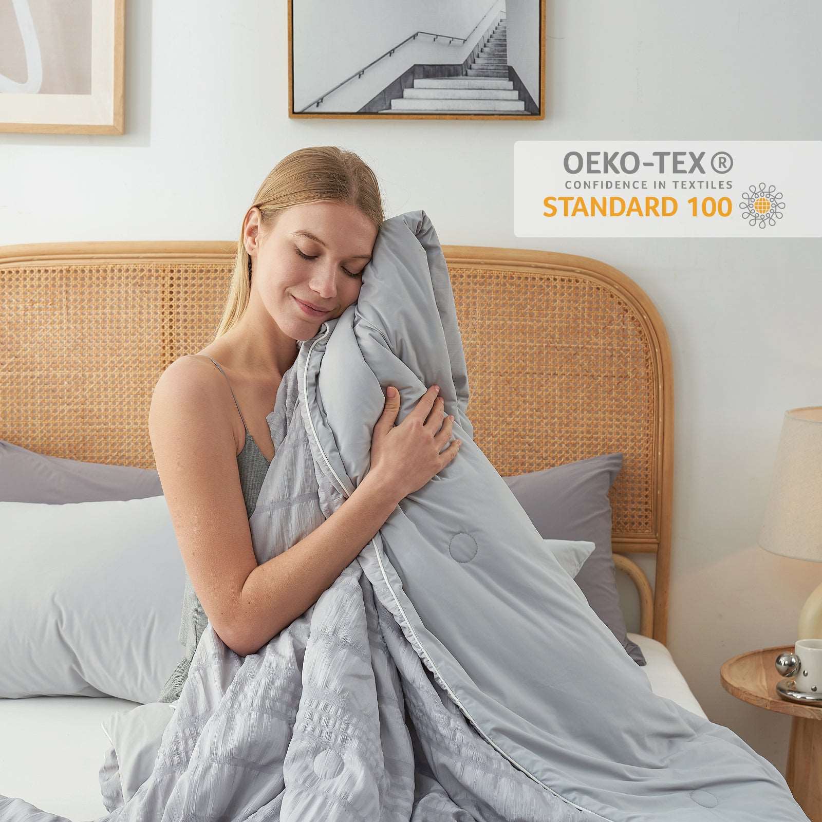 Woman with a gray cooling seersucker comforter. OEKO-TEX certified, breathable blanket for cozy sleep. #color_Light Grey