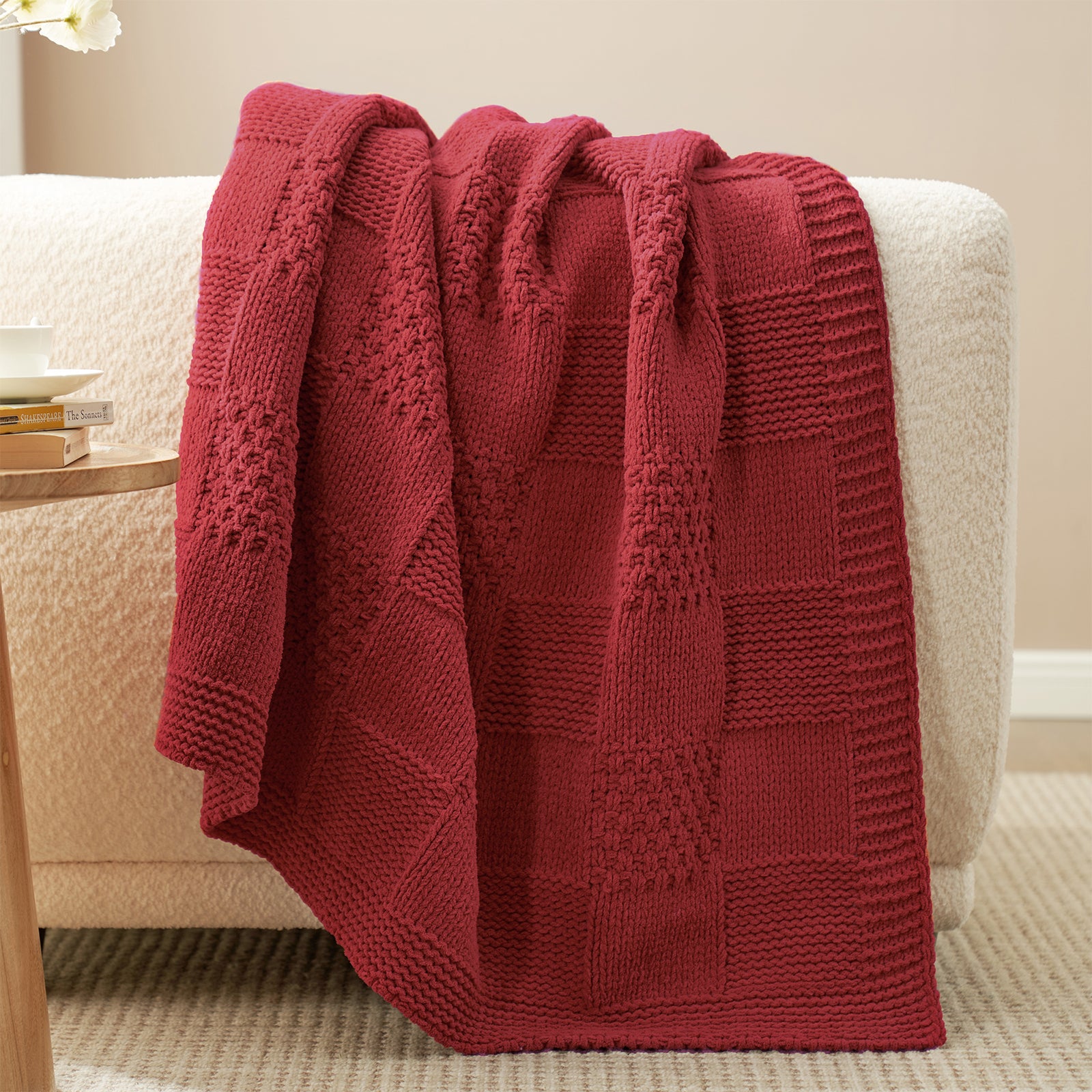 Checkered Chenille Knit Throw Blanket in Red draped over a sofa, highlighting soft chenille texture and detailed checkered knit design. #color_Christmas Red