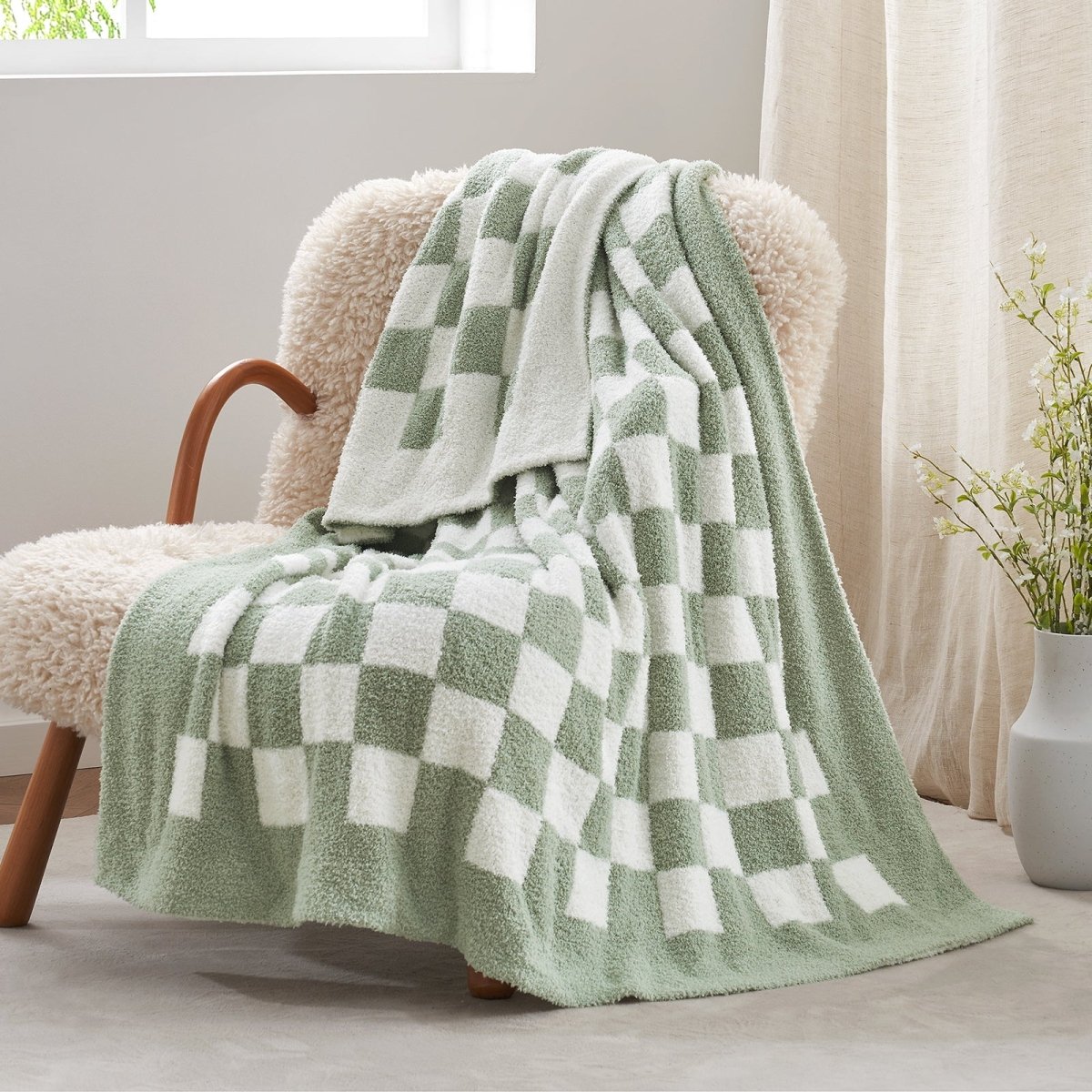Checkered Feather Yarn Knit Throw Blanket in Sage Green & White front view draped over a chair, showcasing soft texture and checkered pattern design. #color_Sage Green & White