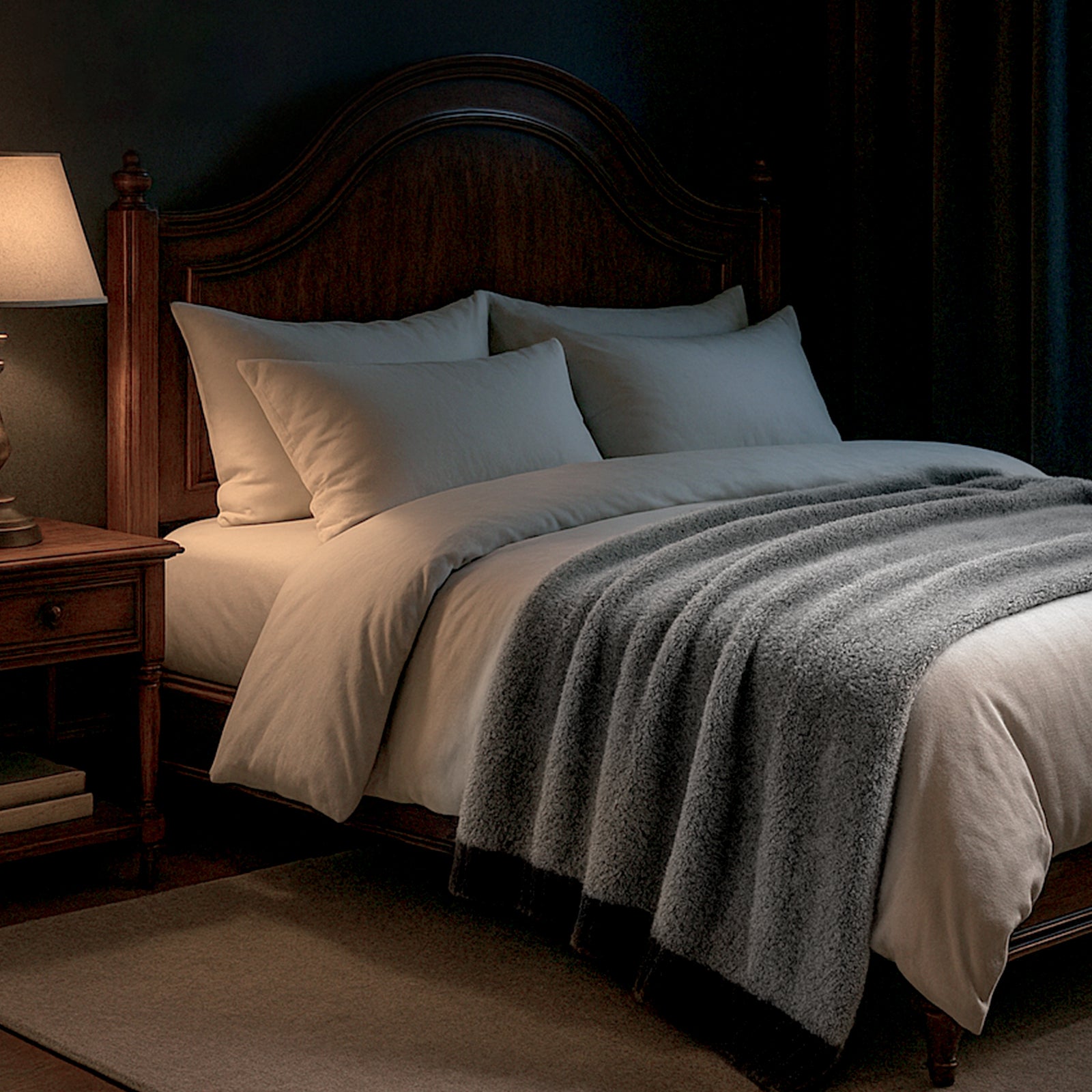 Faux Mink Feather Knit Throw Blanket in Black draped over a bed in a dim bedroom setting, creating a warm and relaxing atmosphere. #color_Black