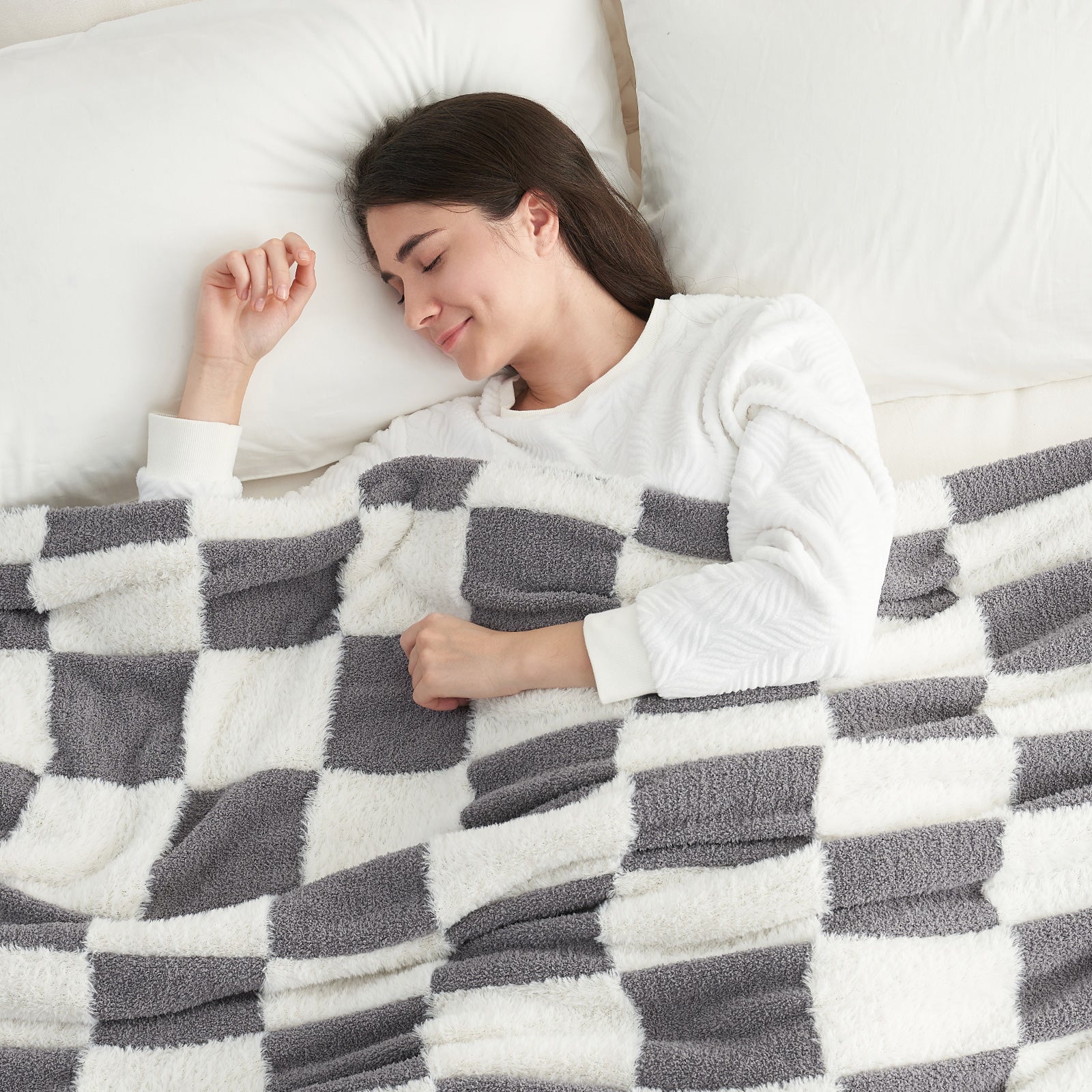 Woman sleeping under a Checkered Faux Fur Feather Yarn Throw Blanket in Grey & White, providing cozy warmth. #color_Grey & White
