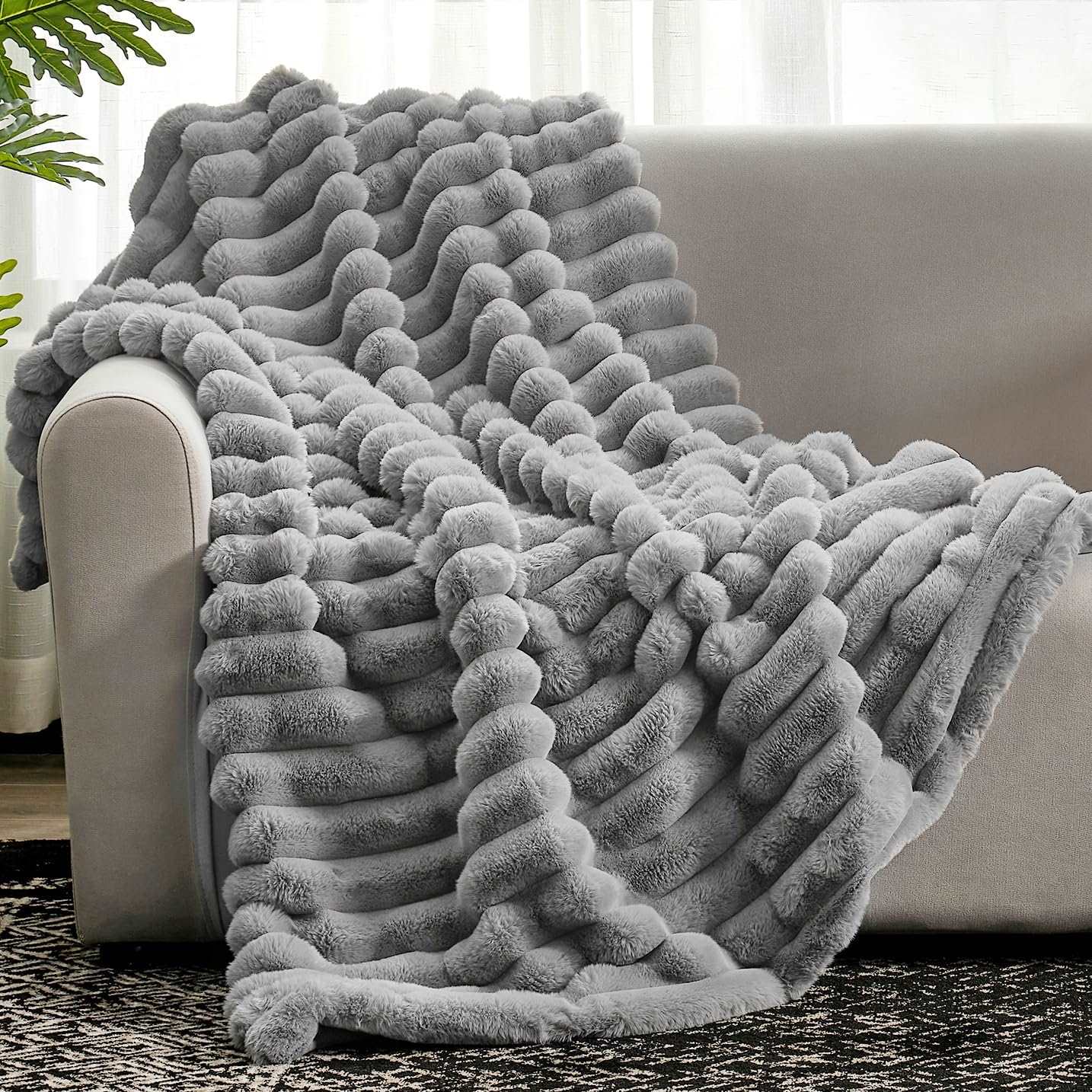 Gray Cozy Bliss Striped Faux Fur Blanket on a sofa, offering soft and cozy comfort. #color_Grey
