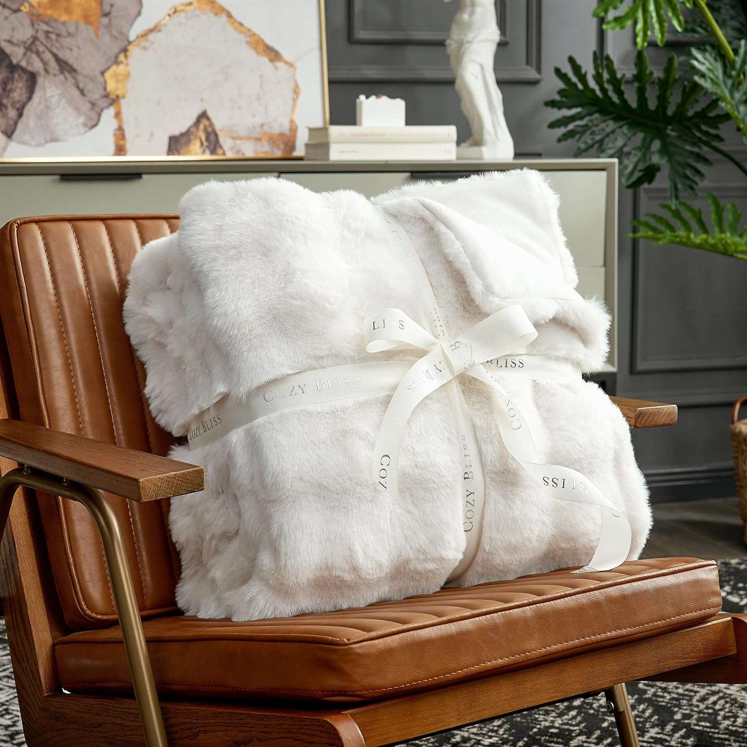 Cozy Bliss white faux fur blanket on leather chair with silk ribbon #color_Cream White