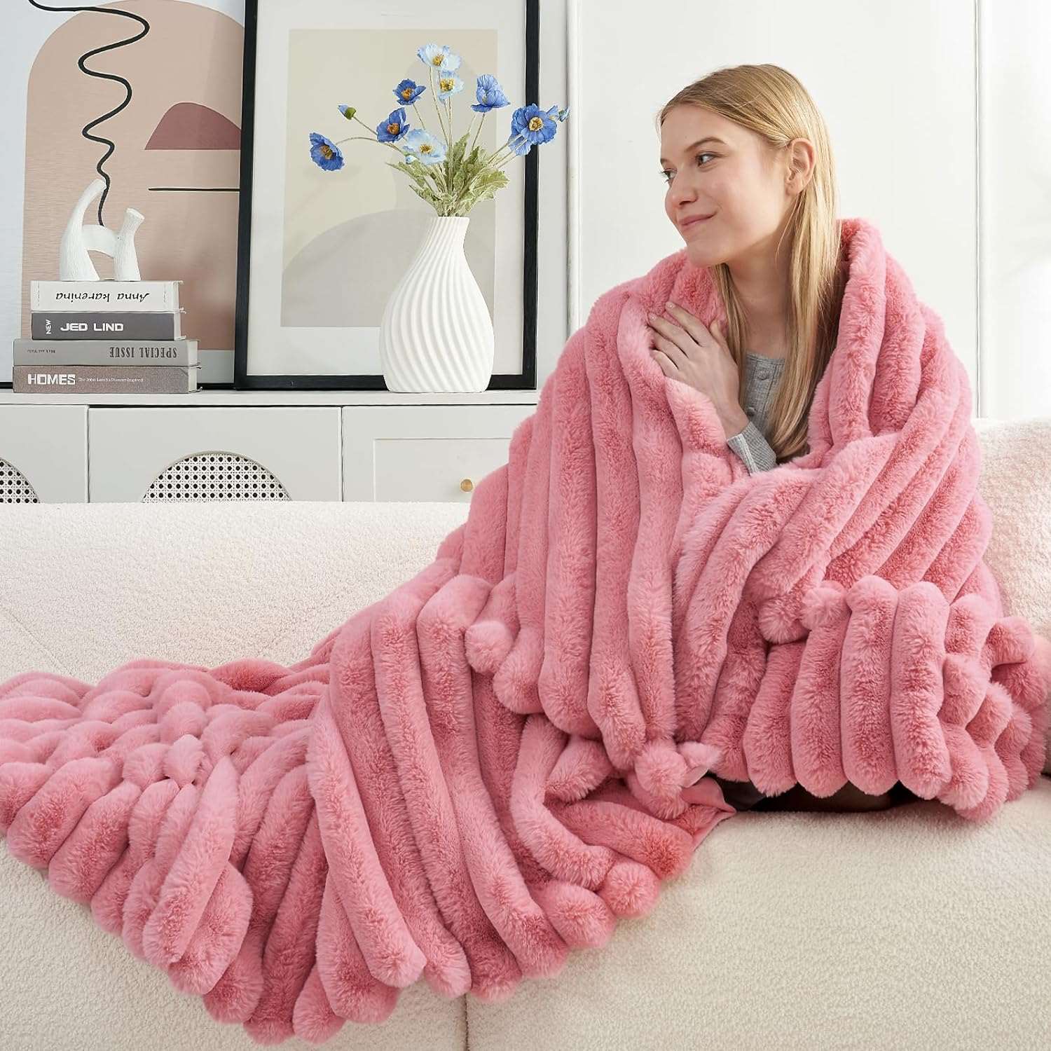 Woman relaxing on sofa with Cozy Bliss pink striped faux fur blanket. #color_Hot Pink